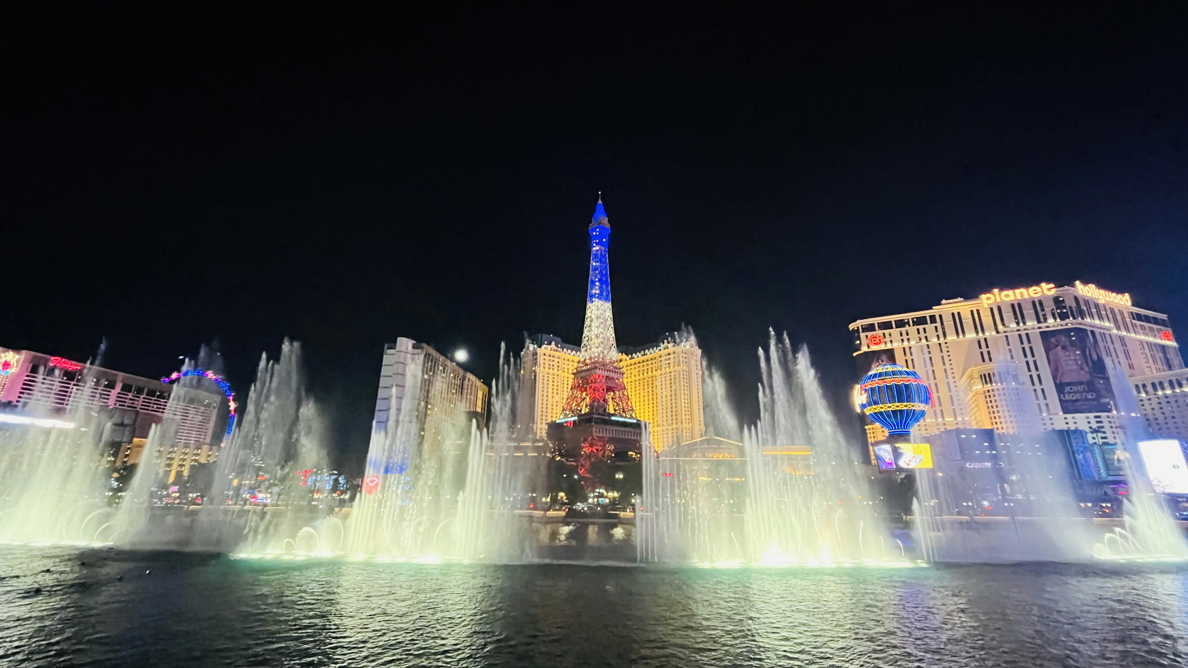 Vista nocturna del espectáculo de fuentes de Las Vegas con luces de colores