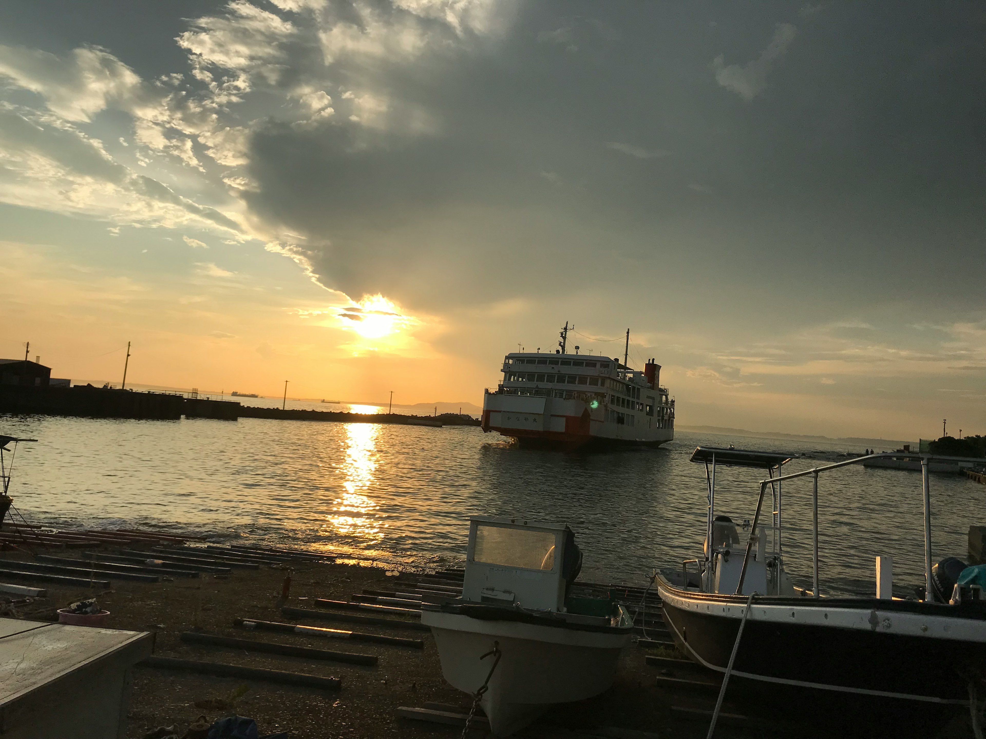 夕日が映る海に船が停泊している風景