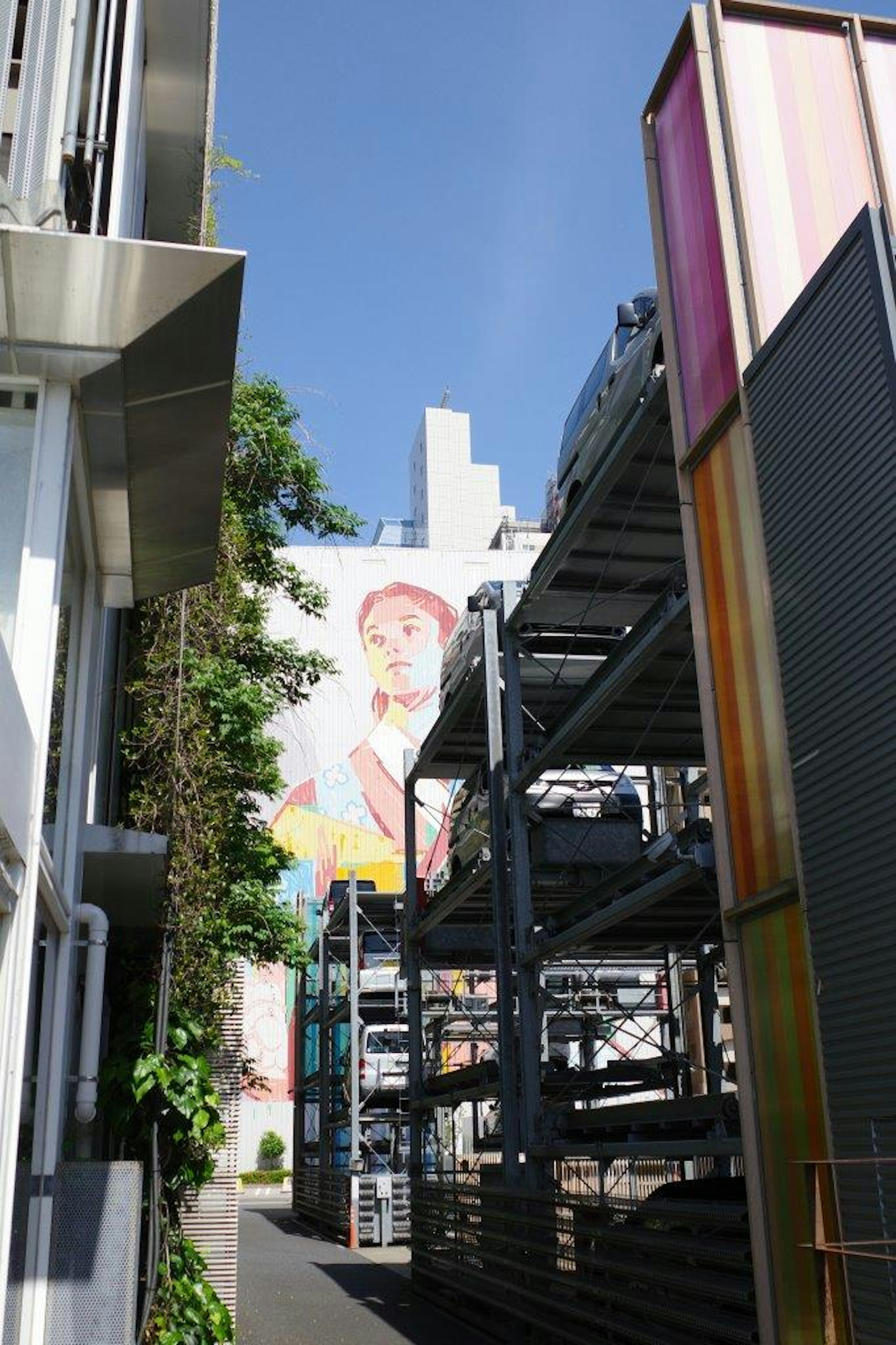 青空の下にあるビル群とカラフルな看板が見える通りの風景