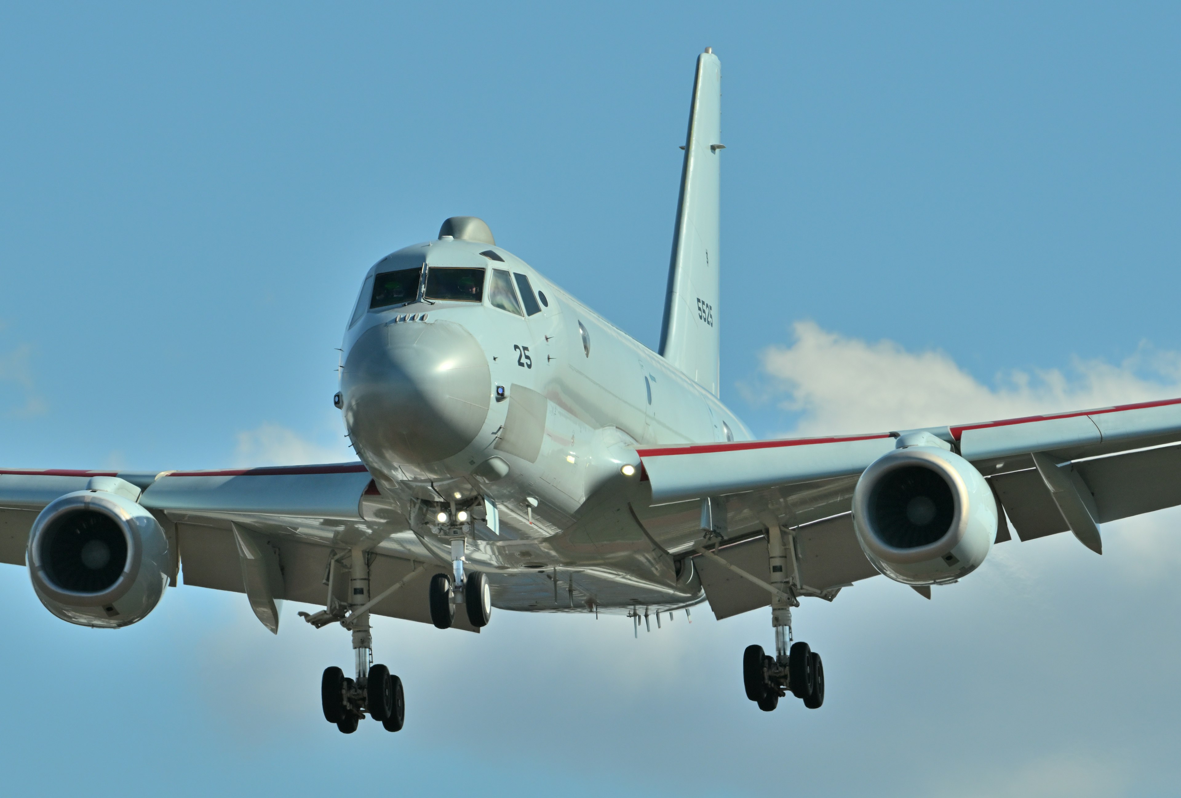 White aircraft approaching against a blue sky