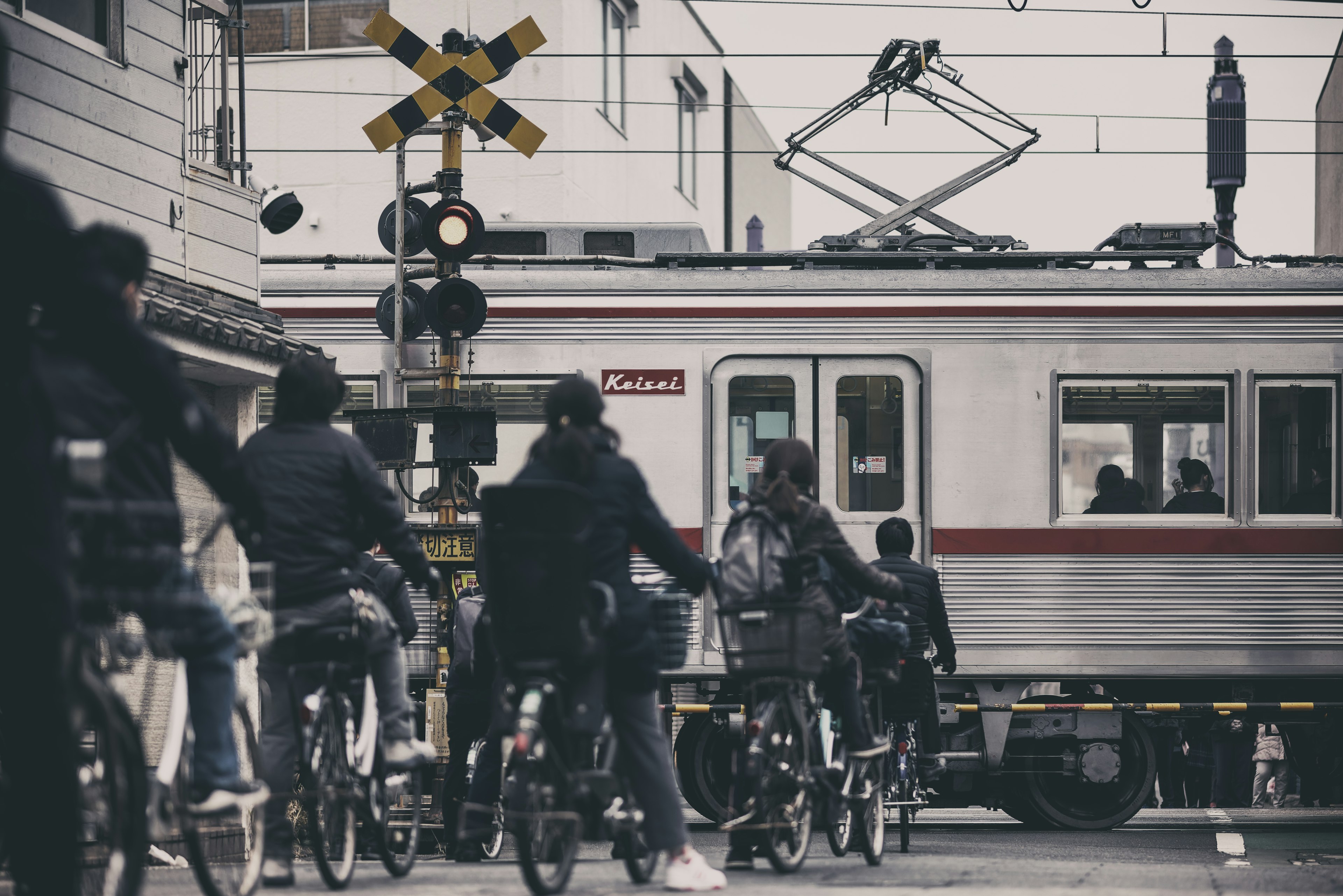 Gruppo di ciclisti che attraversano un passaggio a livello con un treno