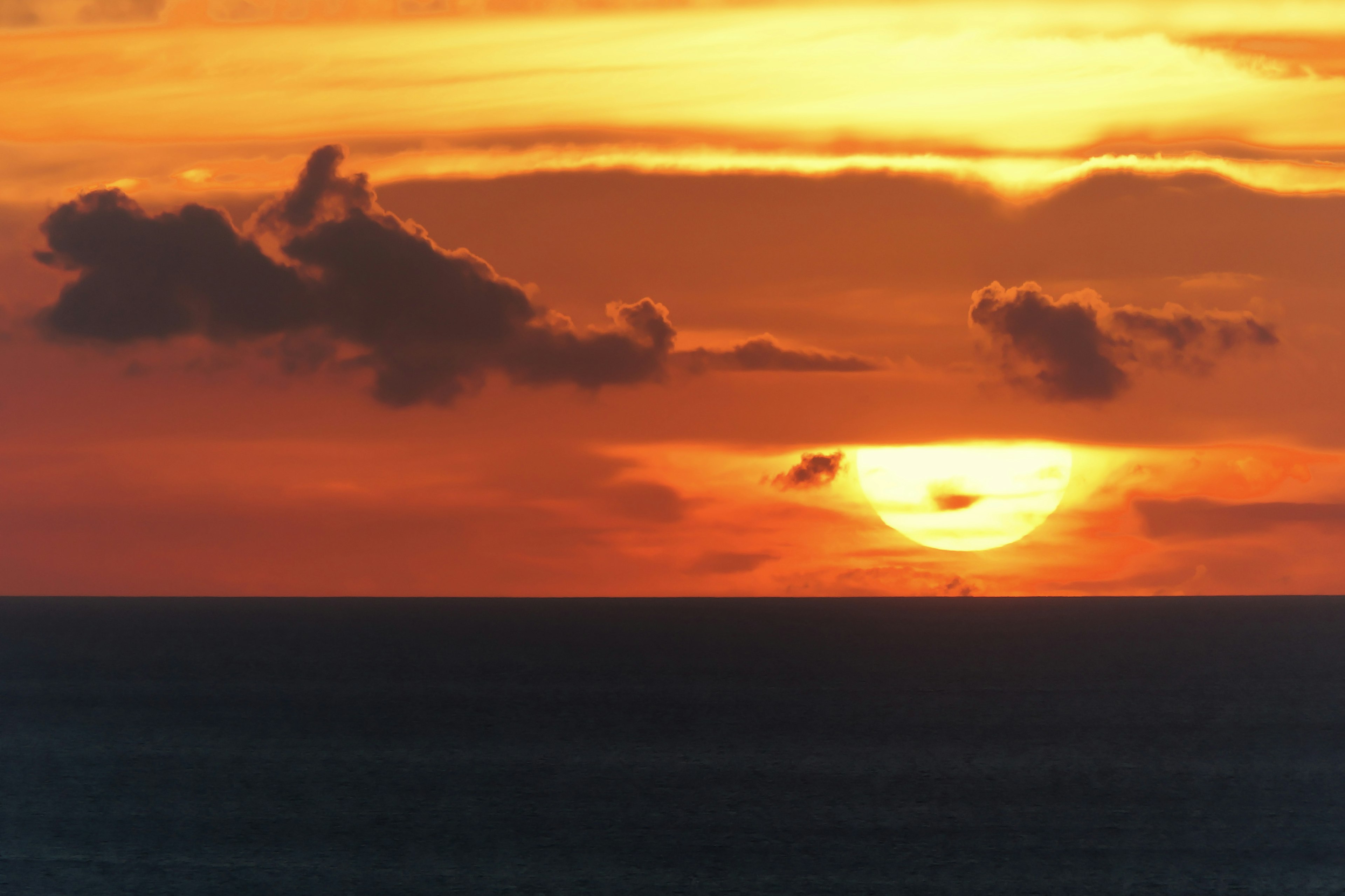 オレンジ色の夕日が海に沈む風景