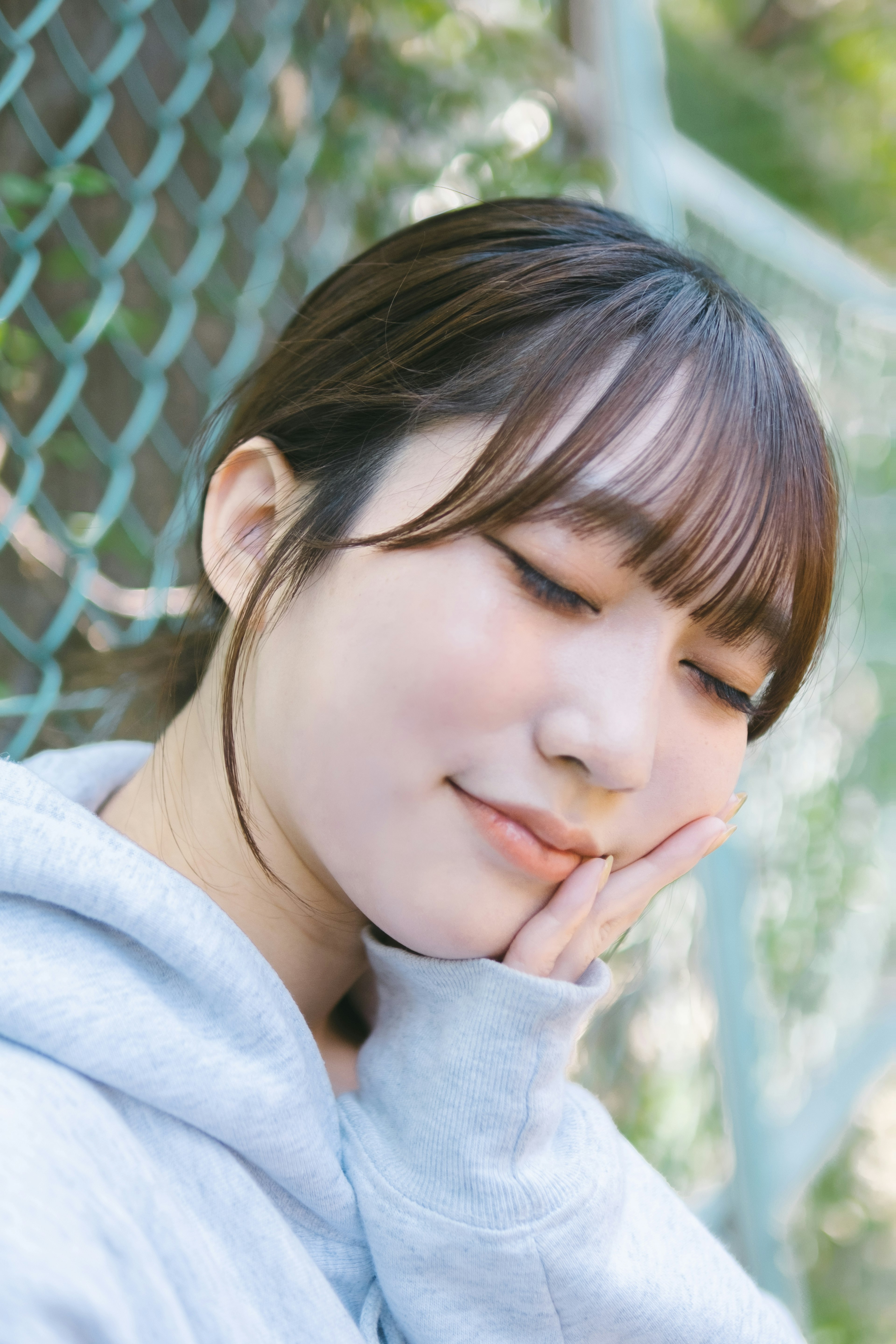 Portrait of a woman smiling softly in front of a blue net