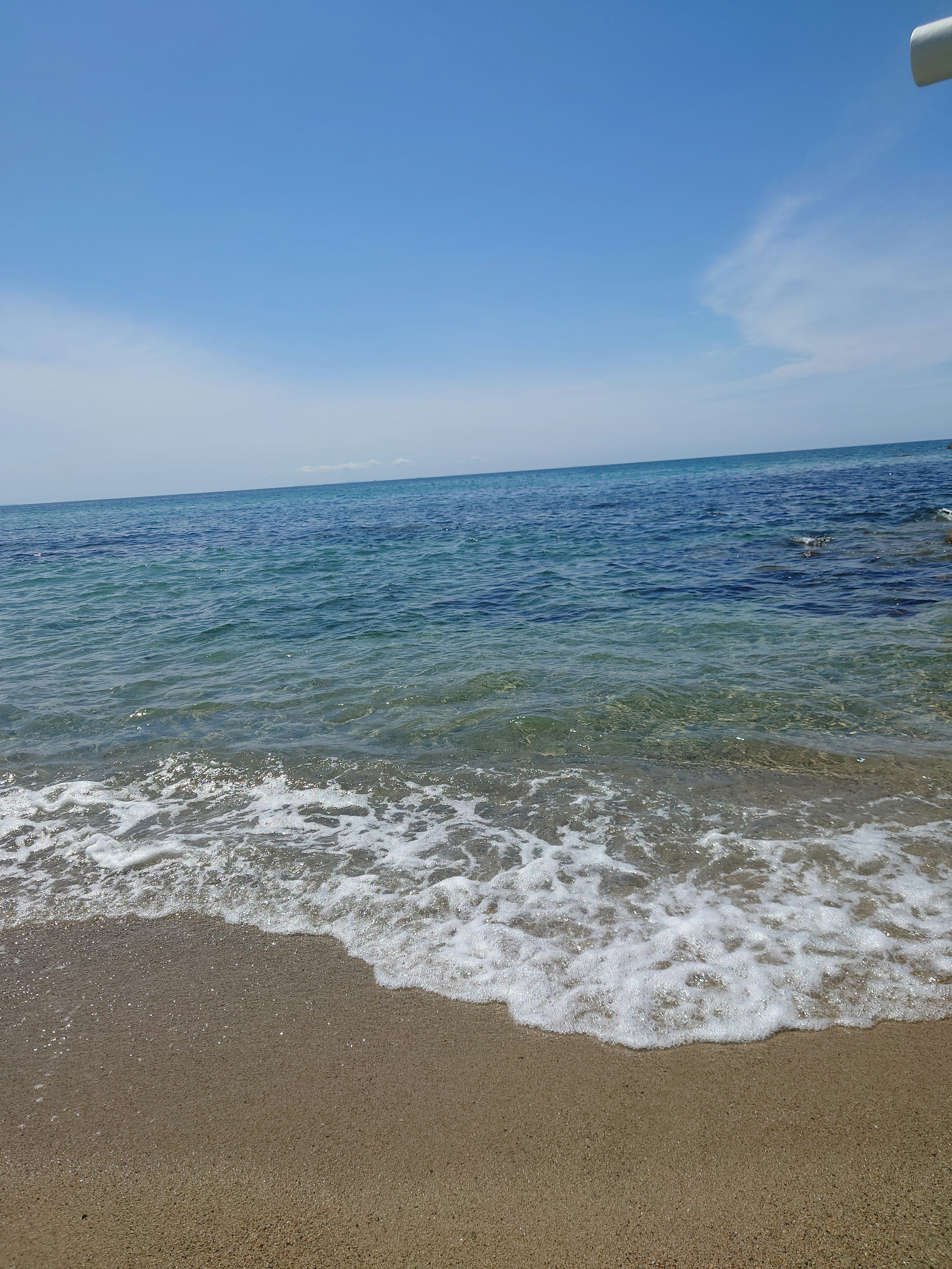 Una vista panoramica di una spiaggia con oceano blu e onde bianche