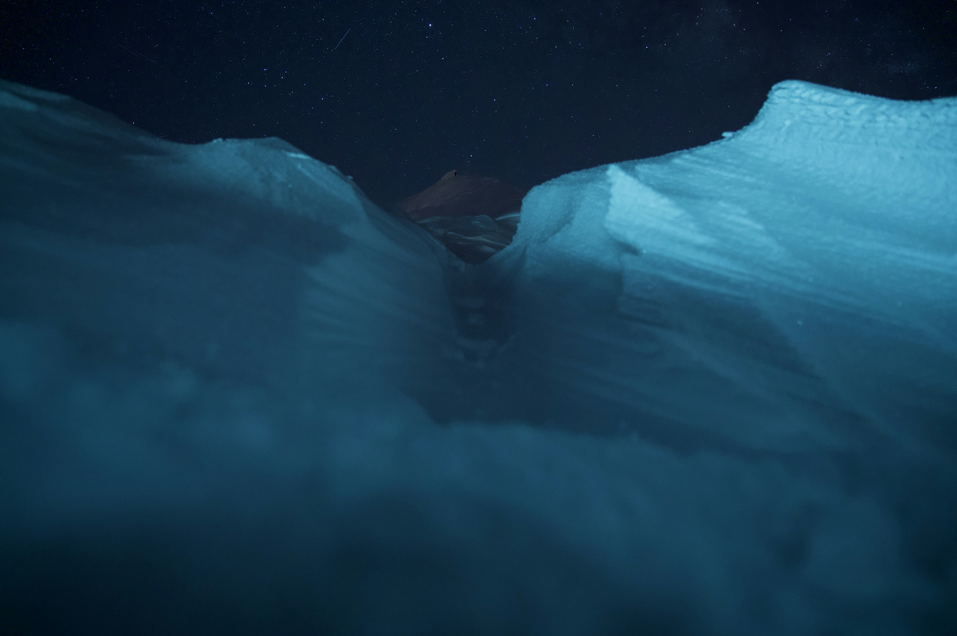 星空の下の青い氷の亀裂と雪の風景