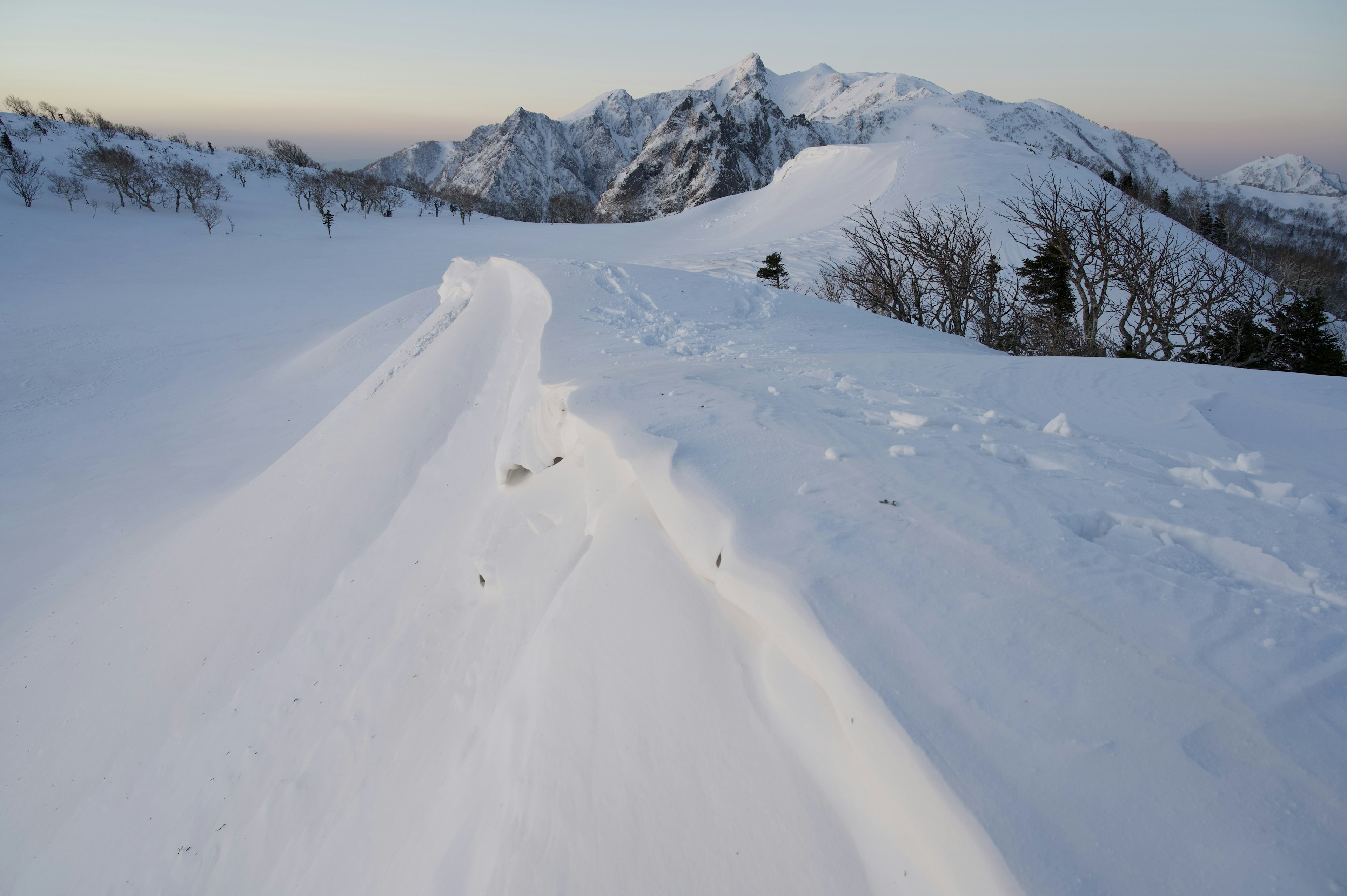 Paesaggio montano coperto di neve con flussi di neve lisci