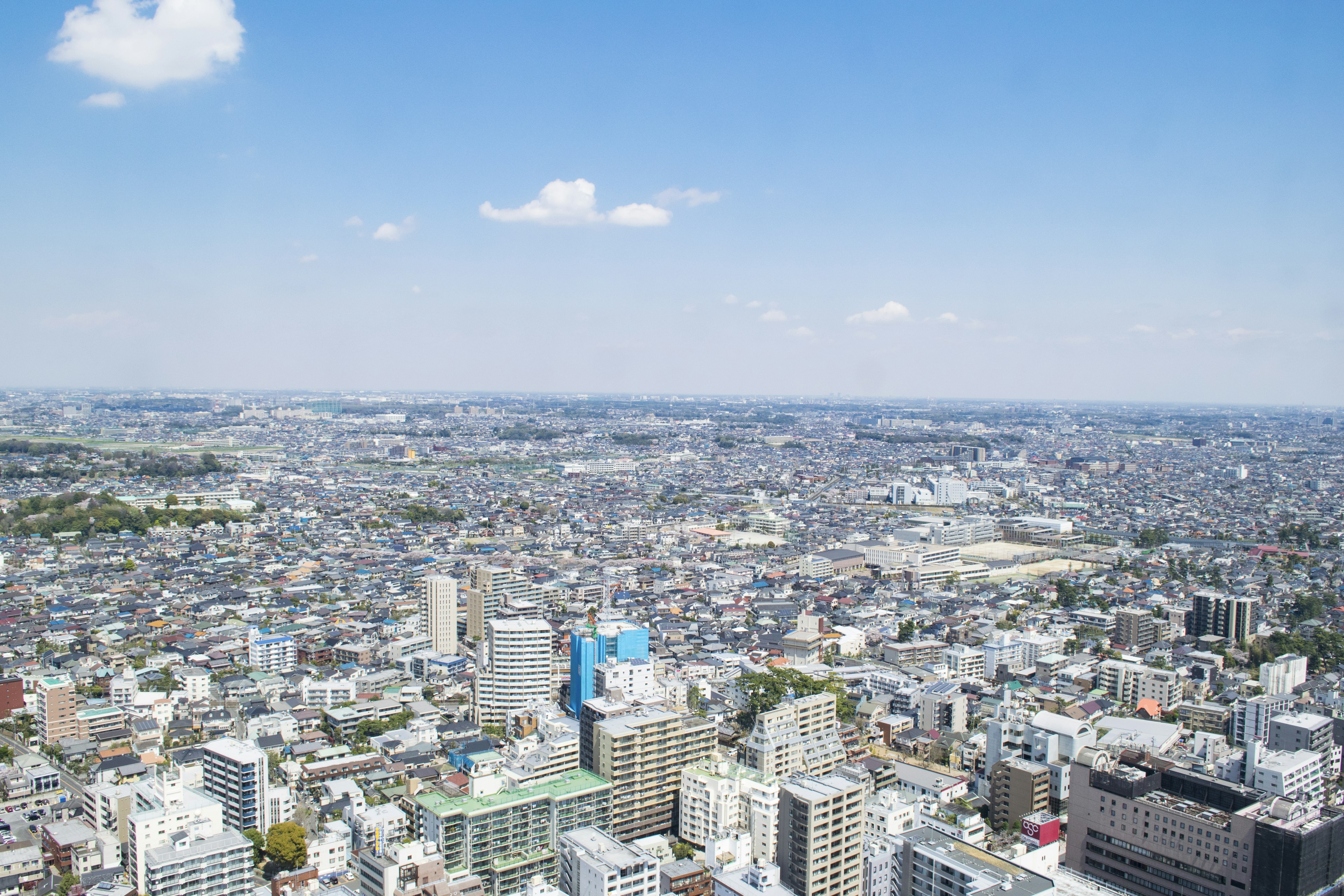 Pemandangan udara lanskap perkotaan Tokyo dengan banyak bangunan dan langit biru yang cerah