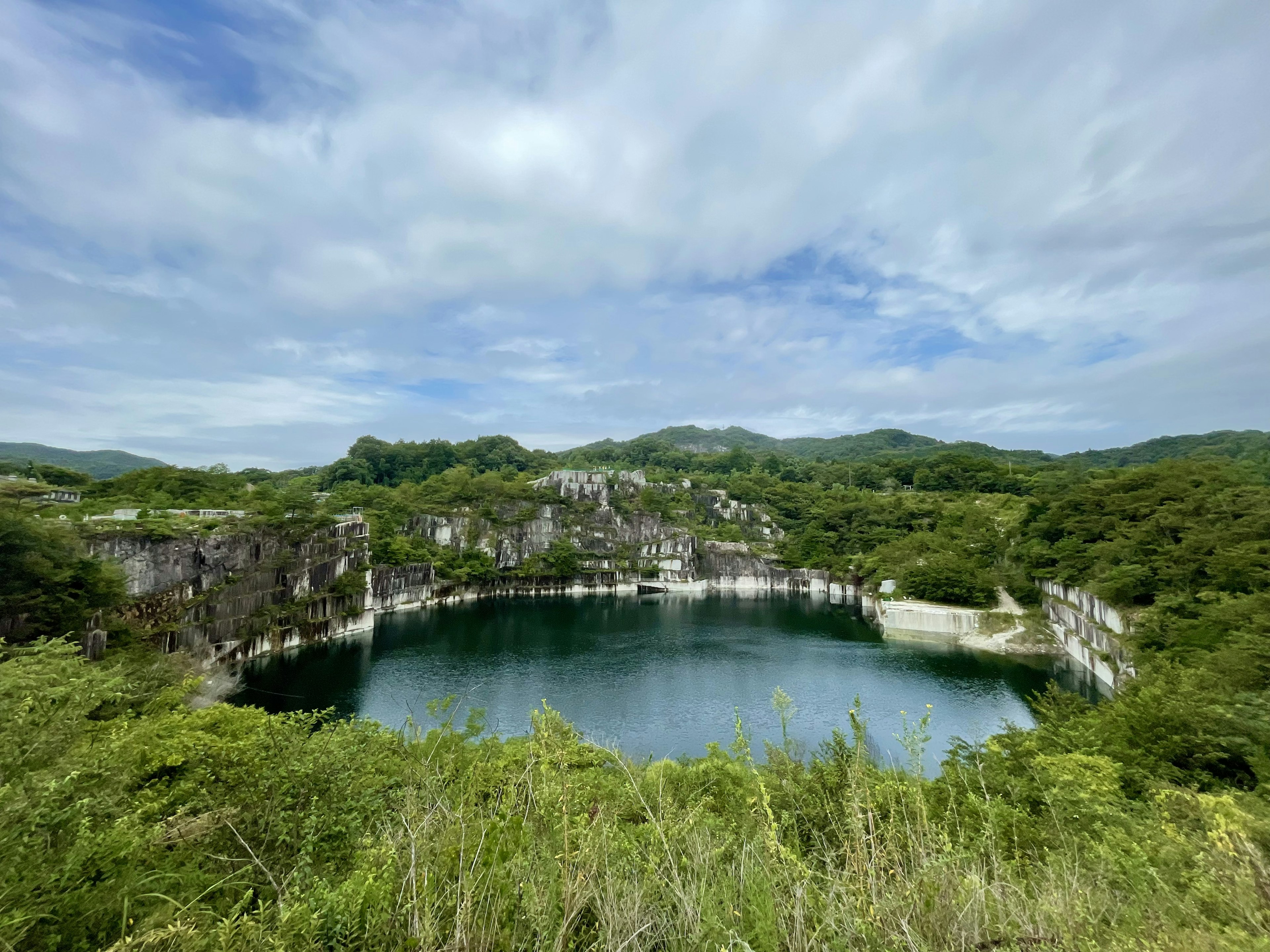 緑に囲まれた静かな湖と青い空の風景