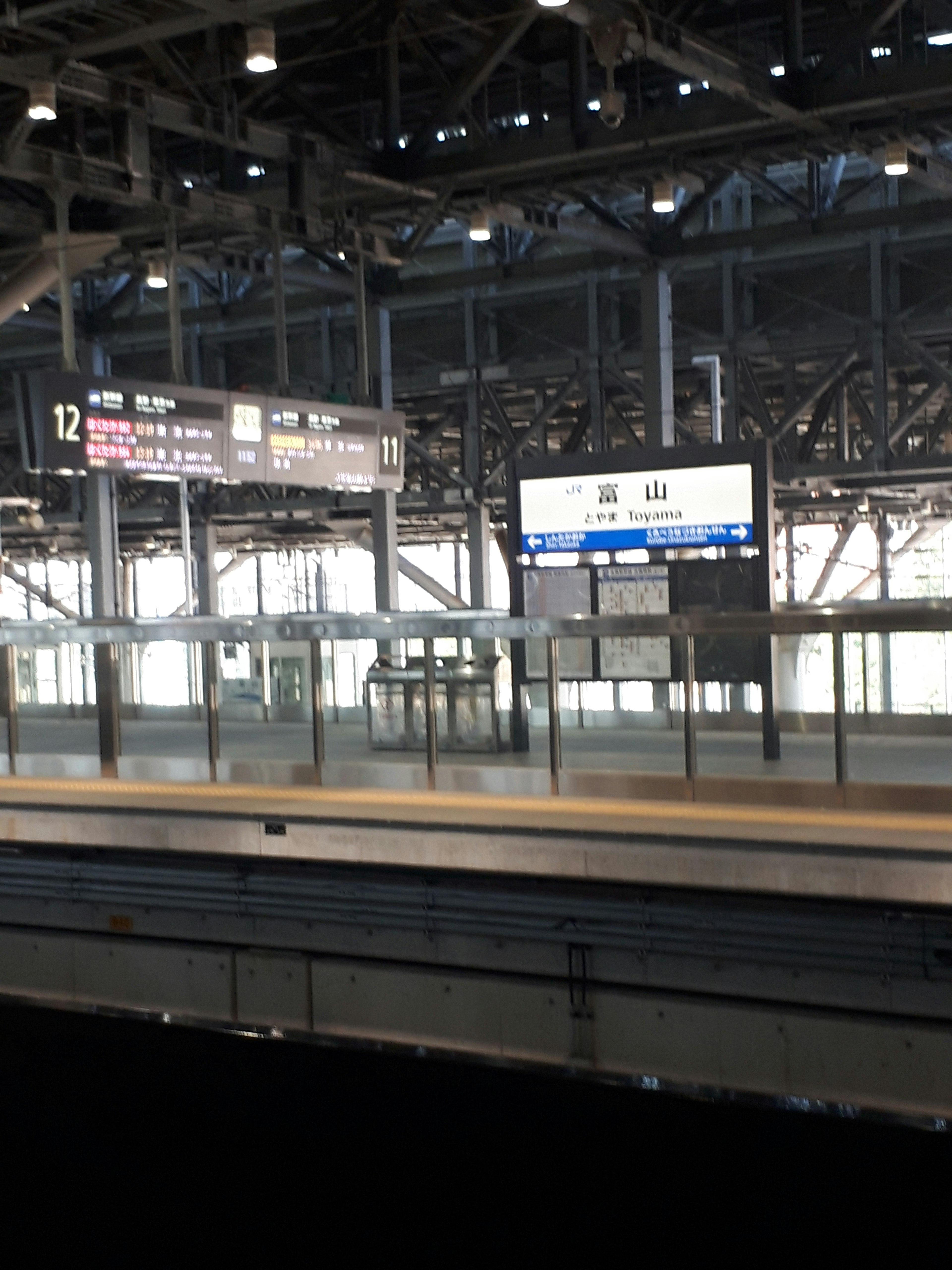 View of a train station platform featuring platform 12 sign and information boards