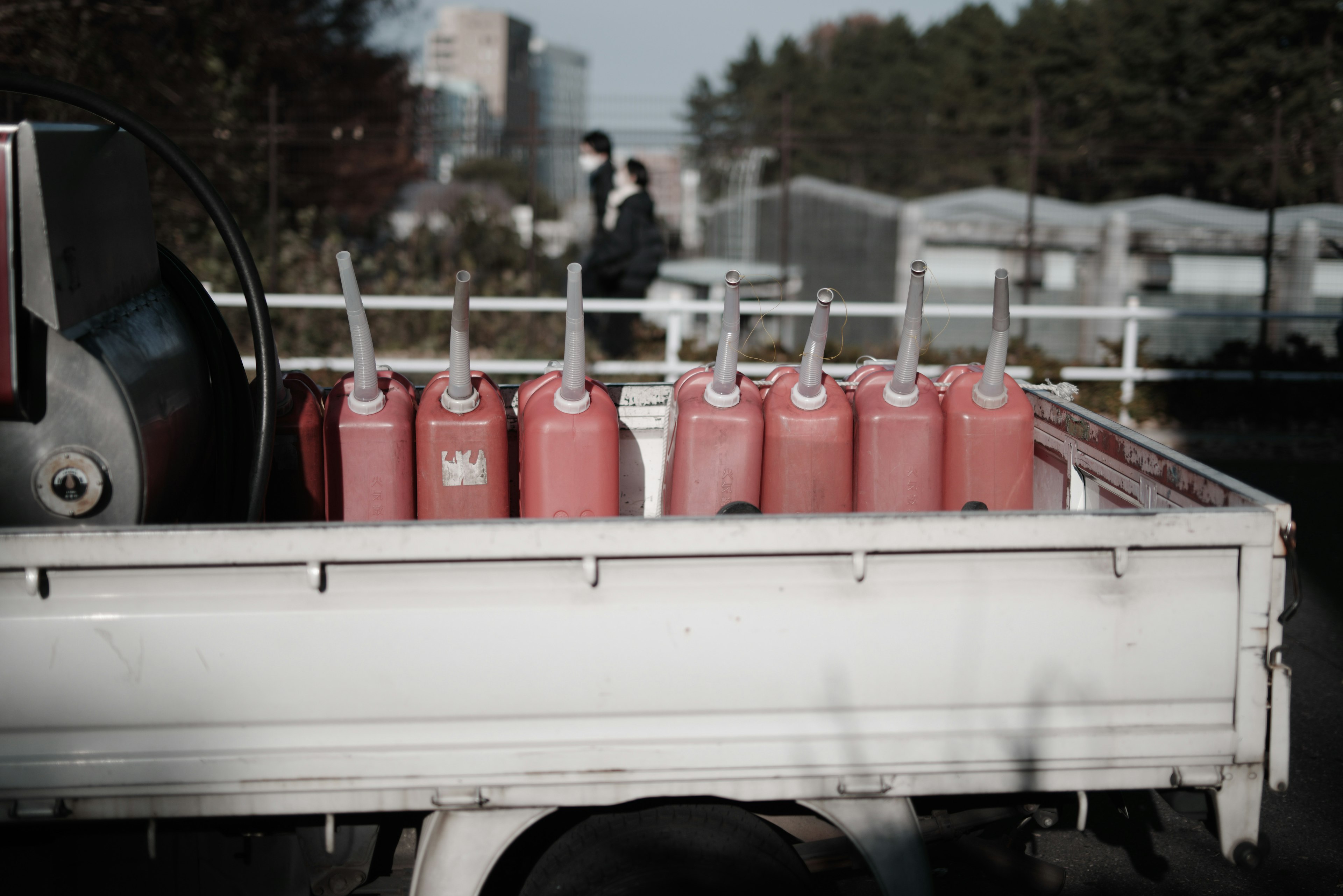 Des bidons d'essence rouges alignés dans la benne d'un camion blanc