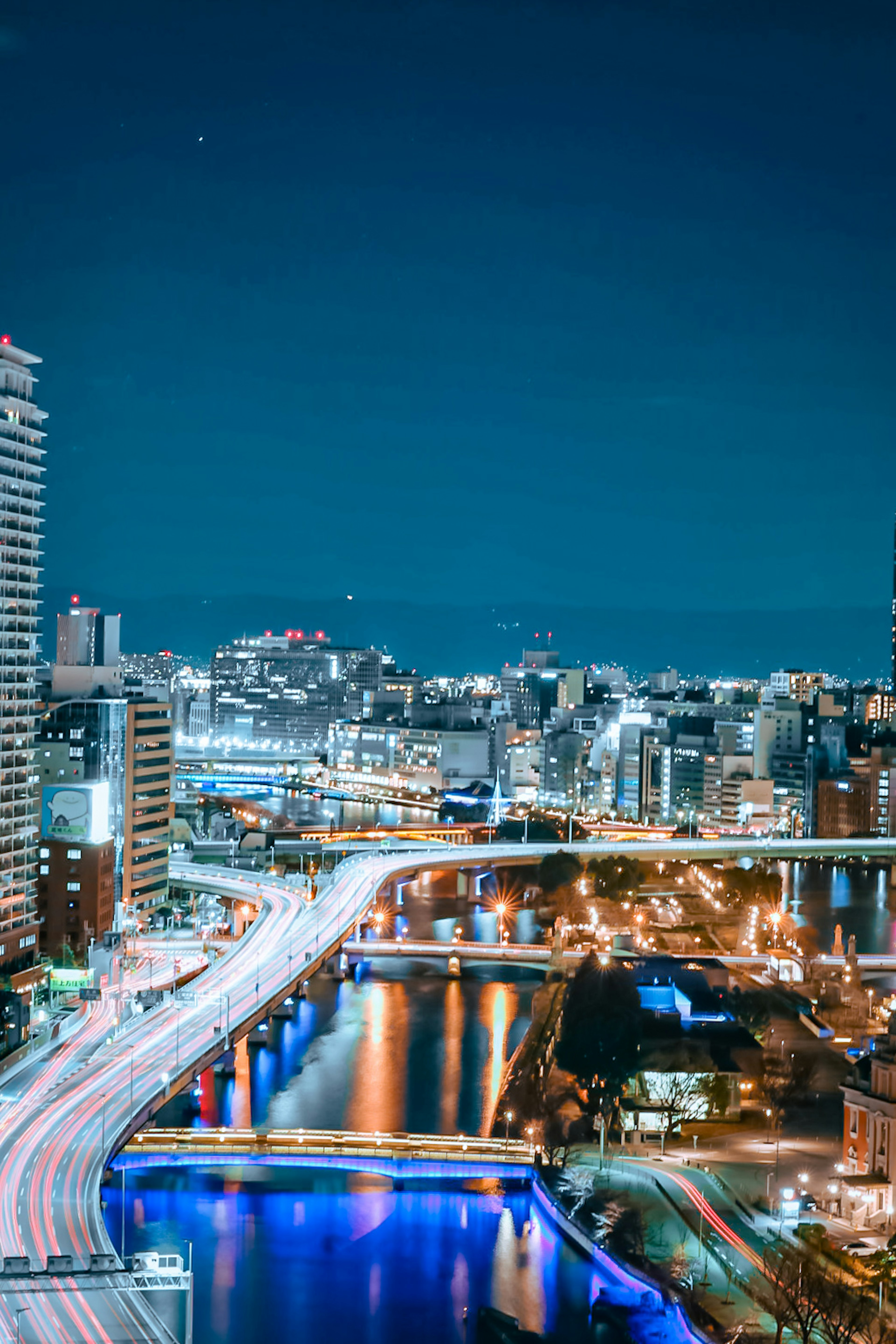 Paisaje urbano nocturno con río iluminado y puentes