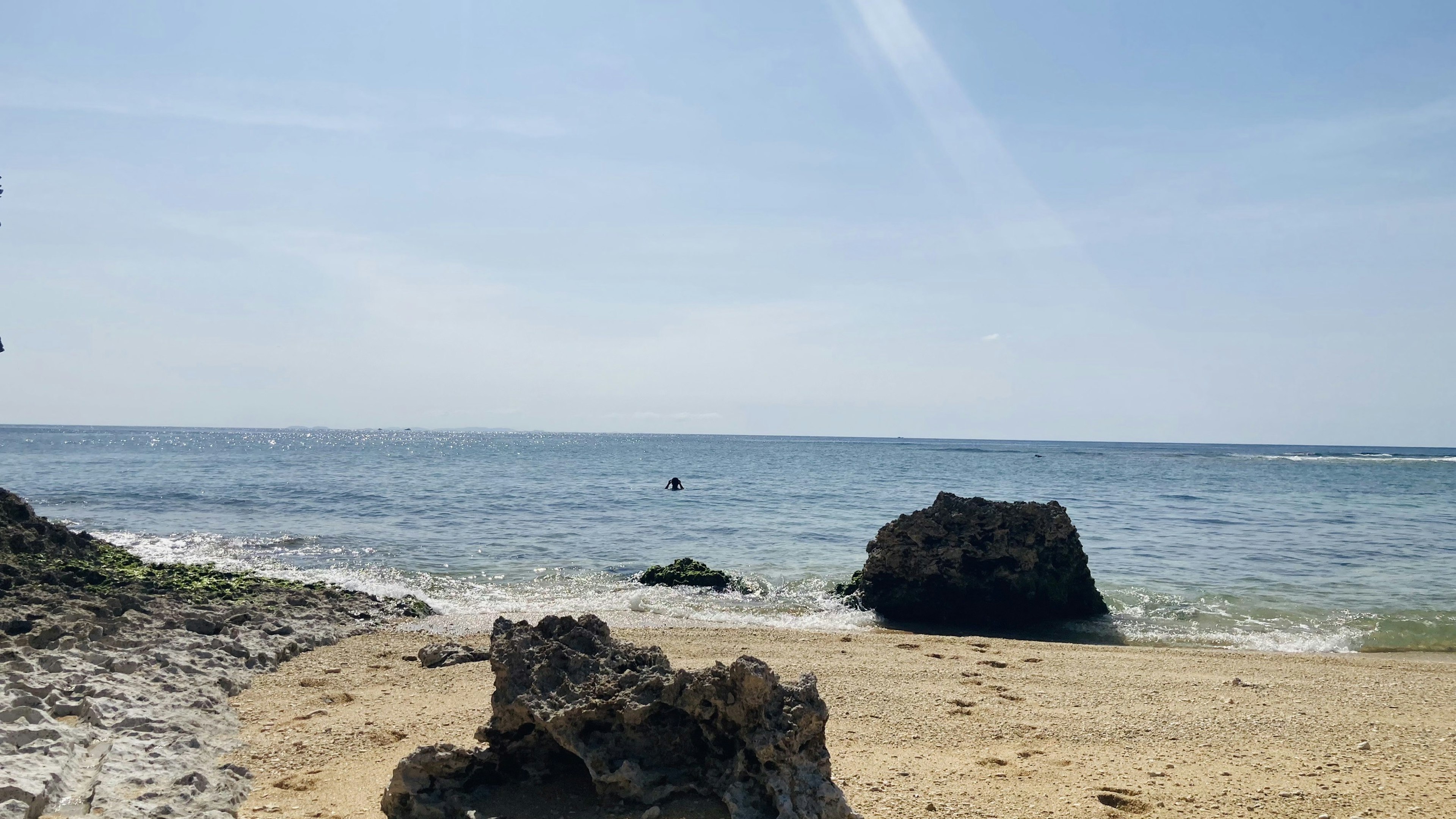 青い空と海が広がるビーチの風景 岩と砂浜が特徴的