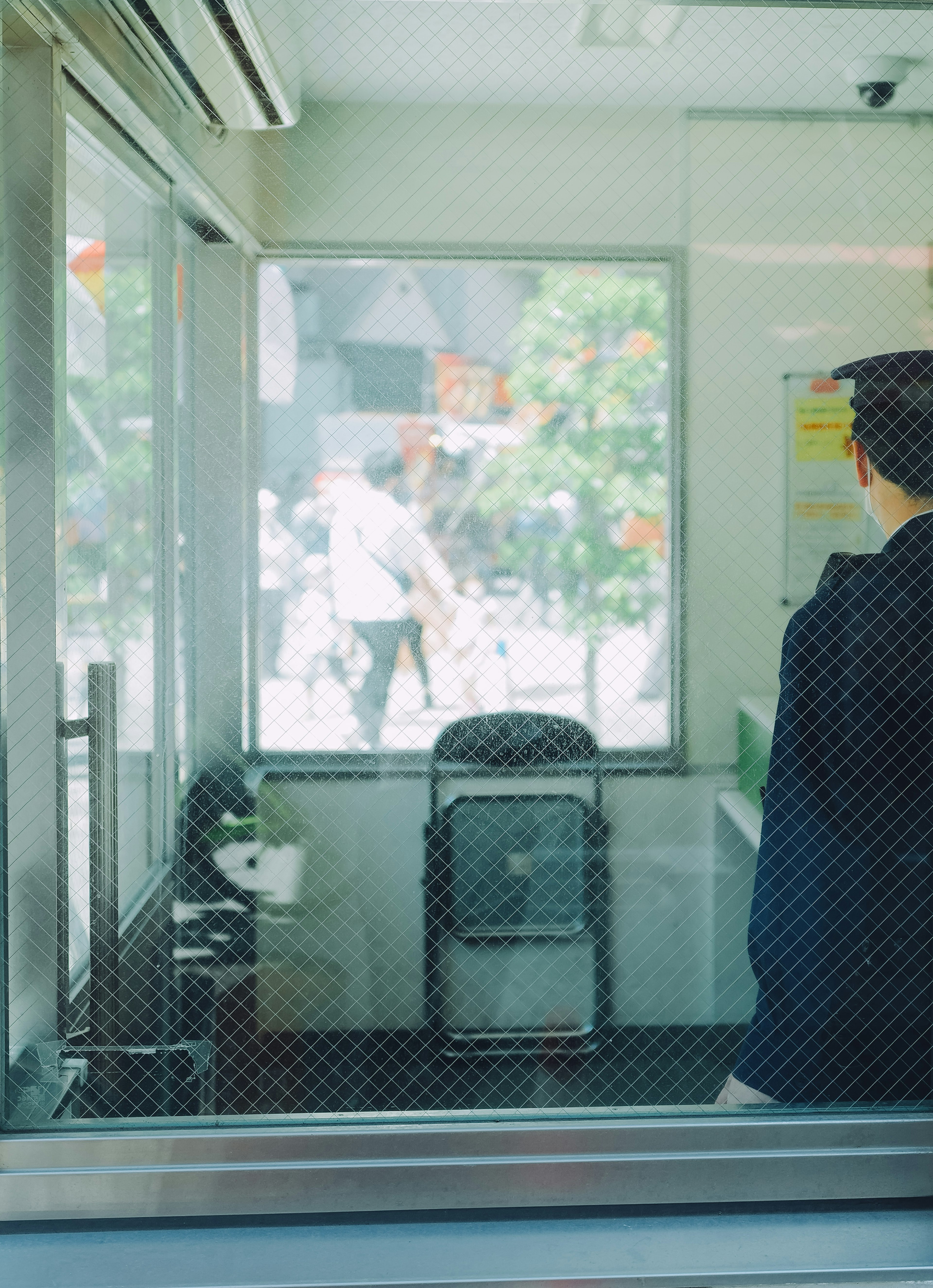 A security guard looking outside through a window