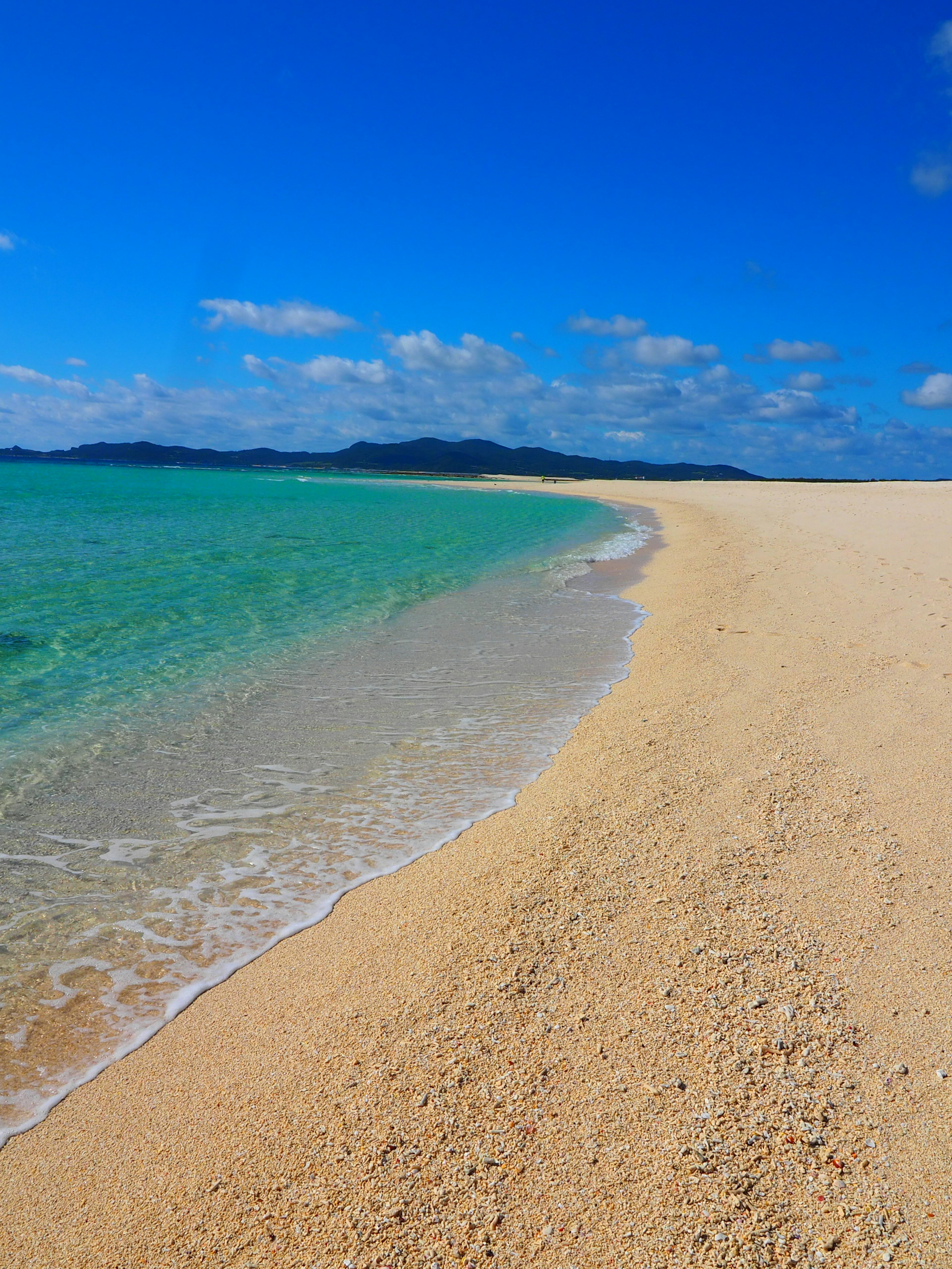 Malersicher Strandblick mit türkisblauem Wasser und goldenem Sand