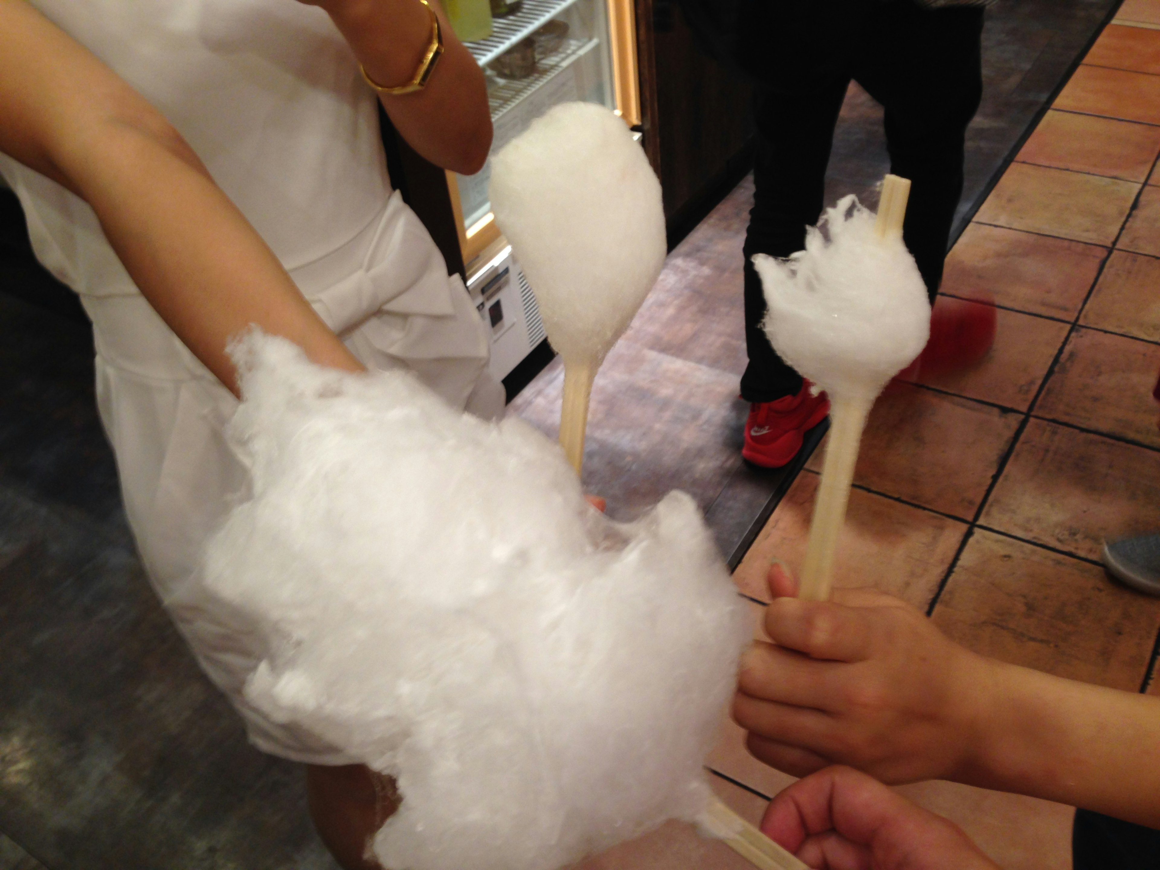 Group of people holding fluffy cotton candy in various shapes