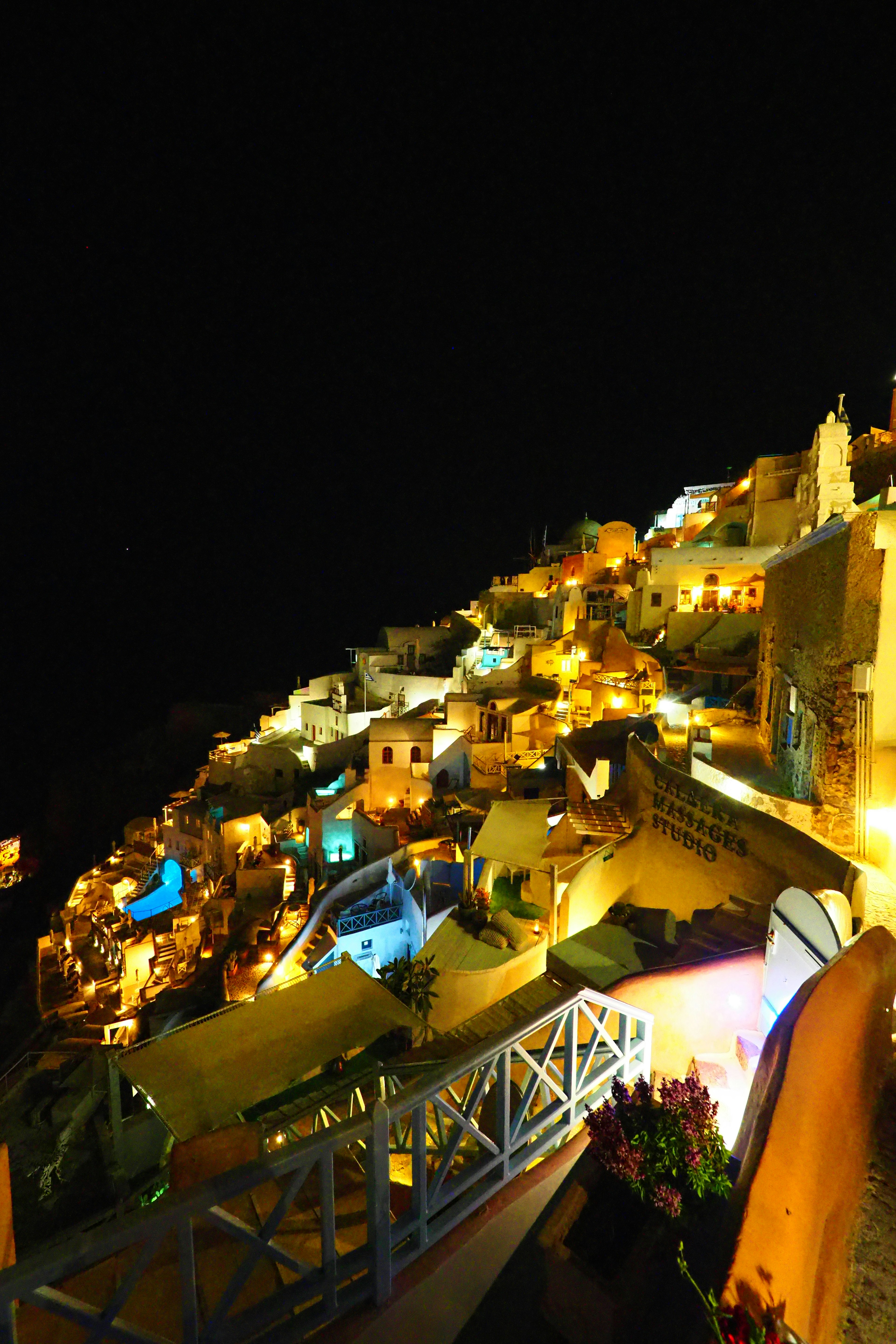 Vue nocturne de Santorin avec des maisons et des chemins illuminés