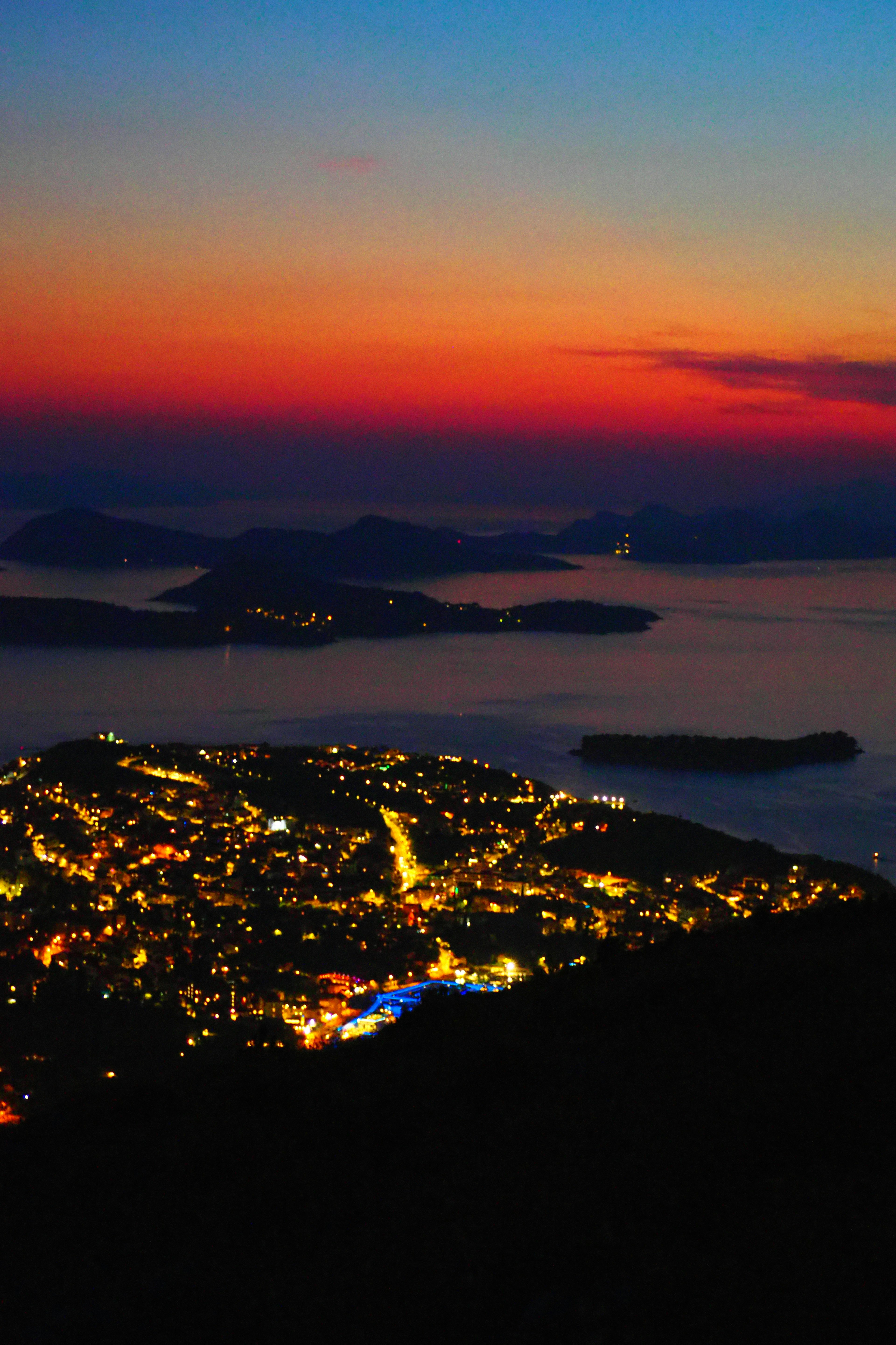 City nightscape with sunset sky and sea in the background