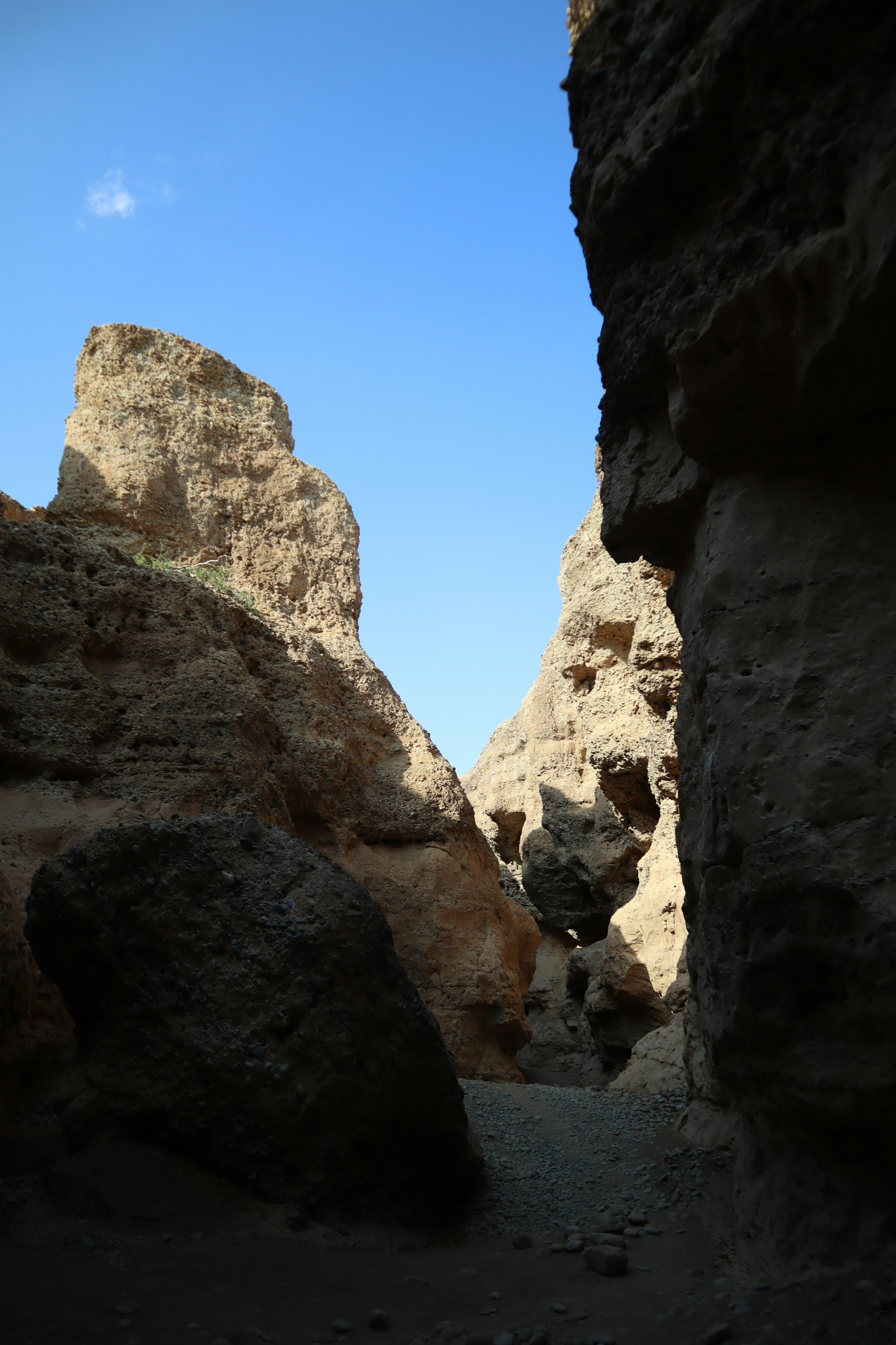 Narrow canyon surrounded by rocky cliffs with clear blue sky