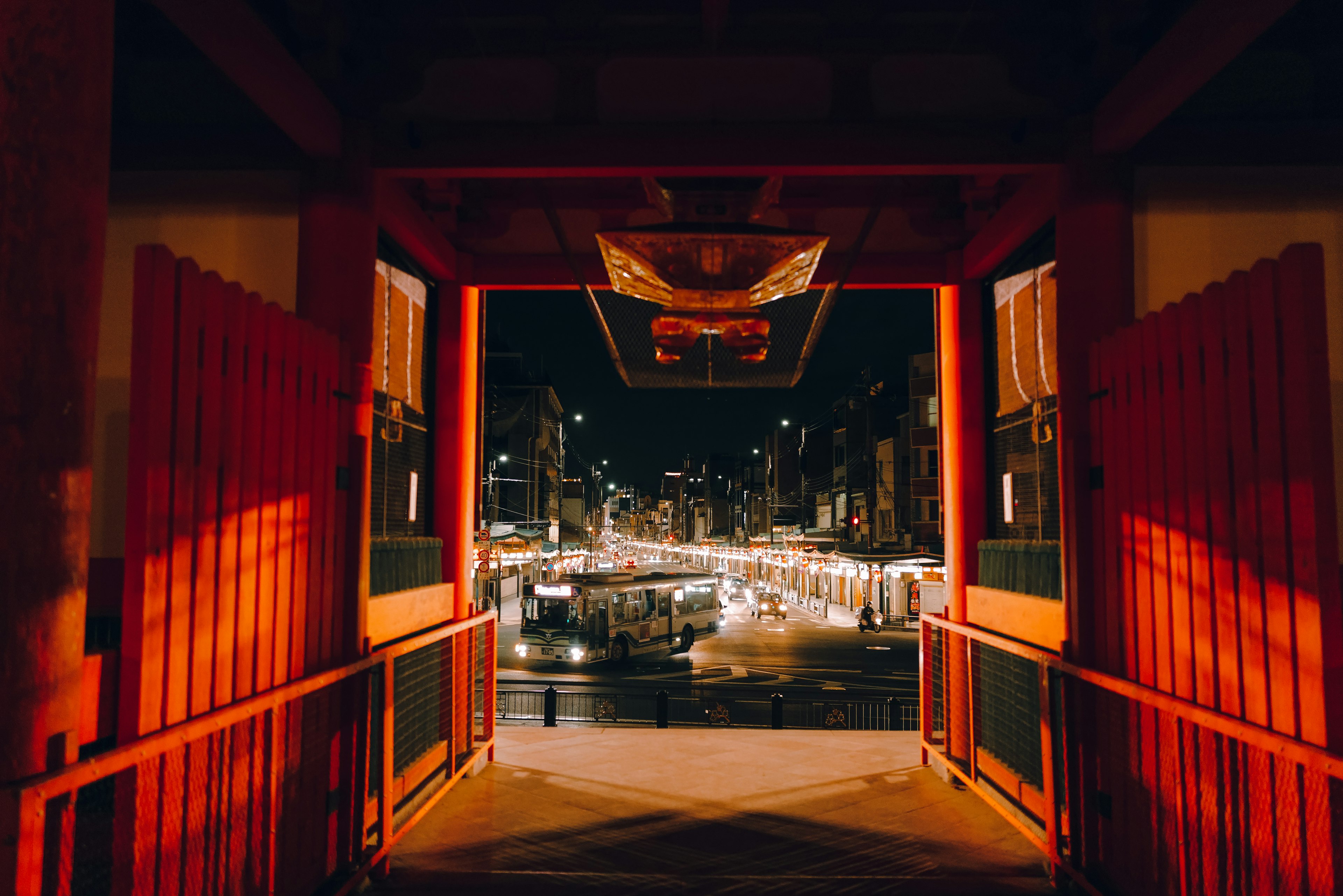 Vista a través de una puerta roja que muestra un paisaje urbano nocturno