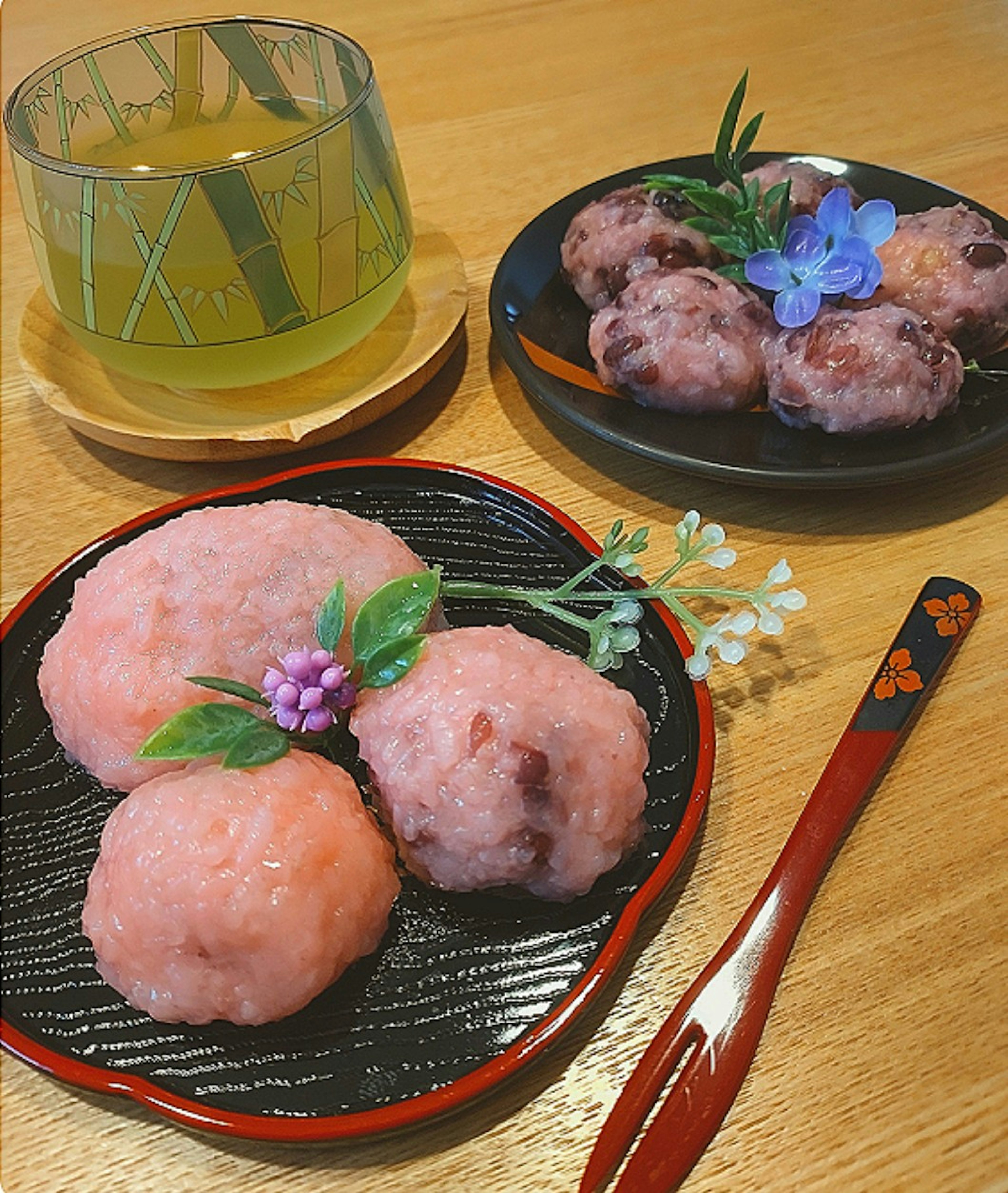 Piring kue Jepang dengan dekorasi sakura dan teh hijau