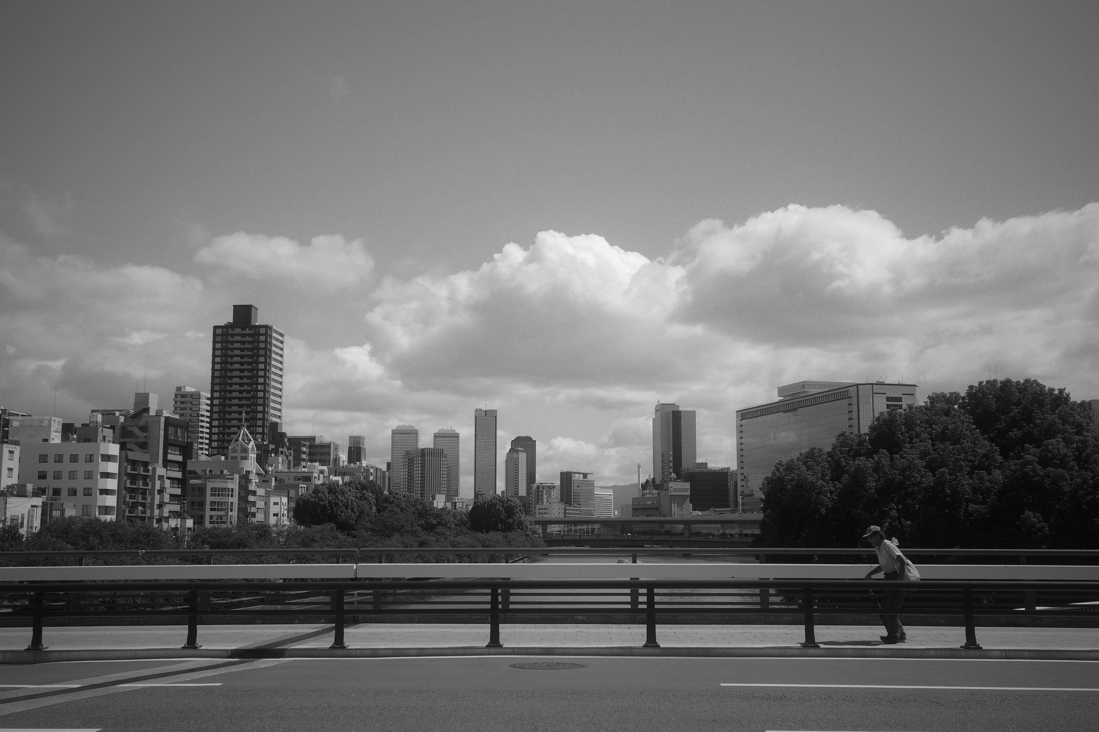 Black and white cityscape featuring buildings and cloudy sky