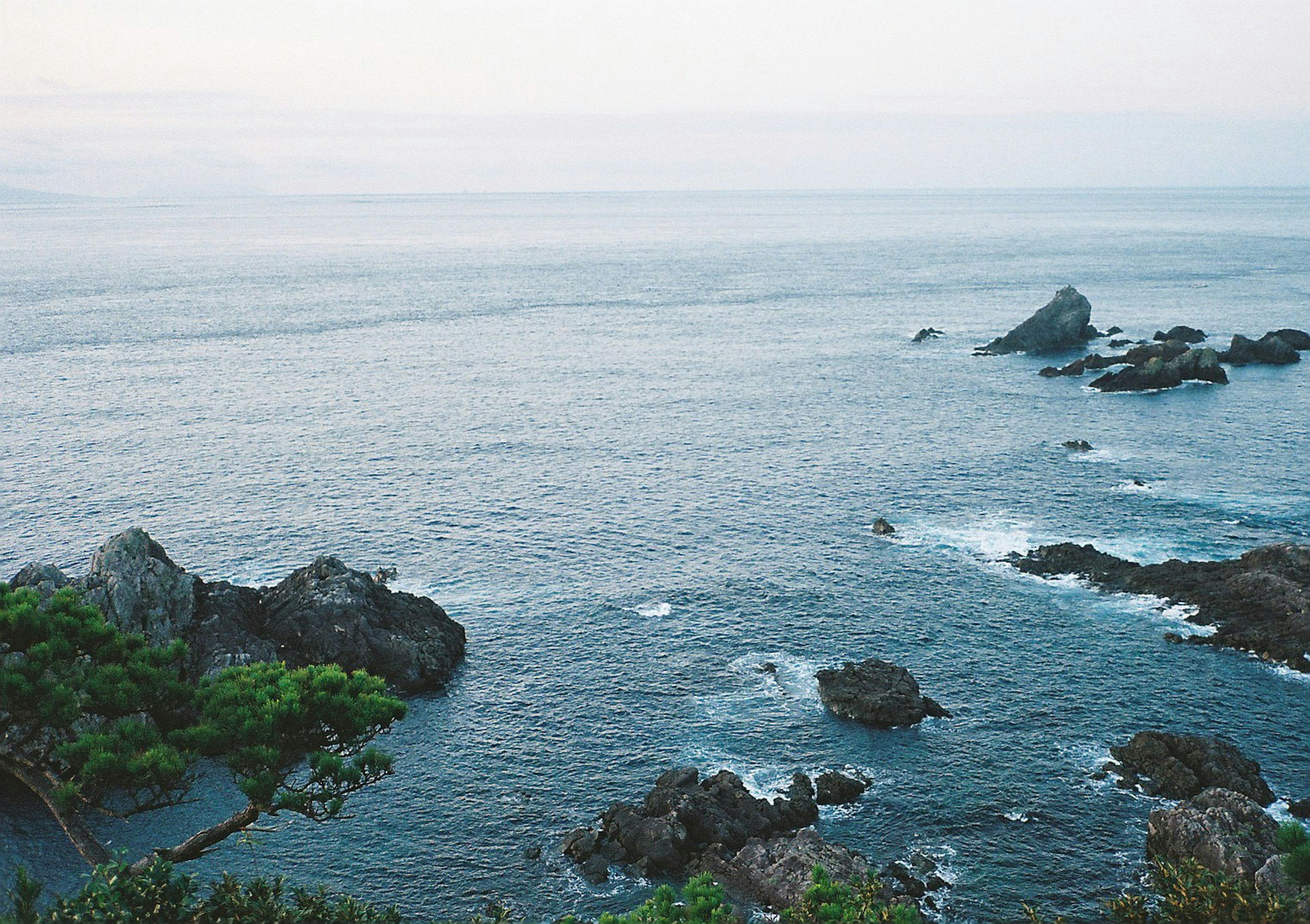 Pemandangan pantai yang tenang dengan batu dan laut tenang