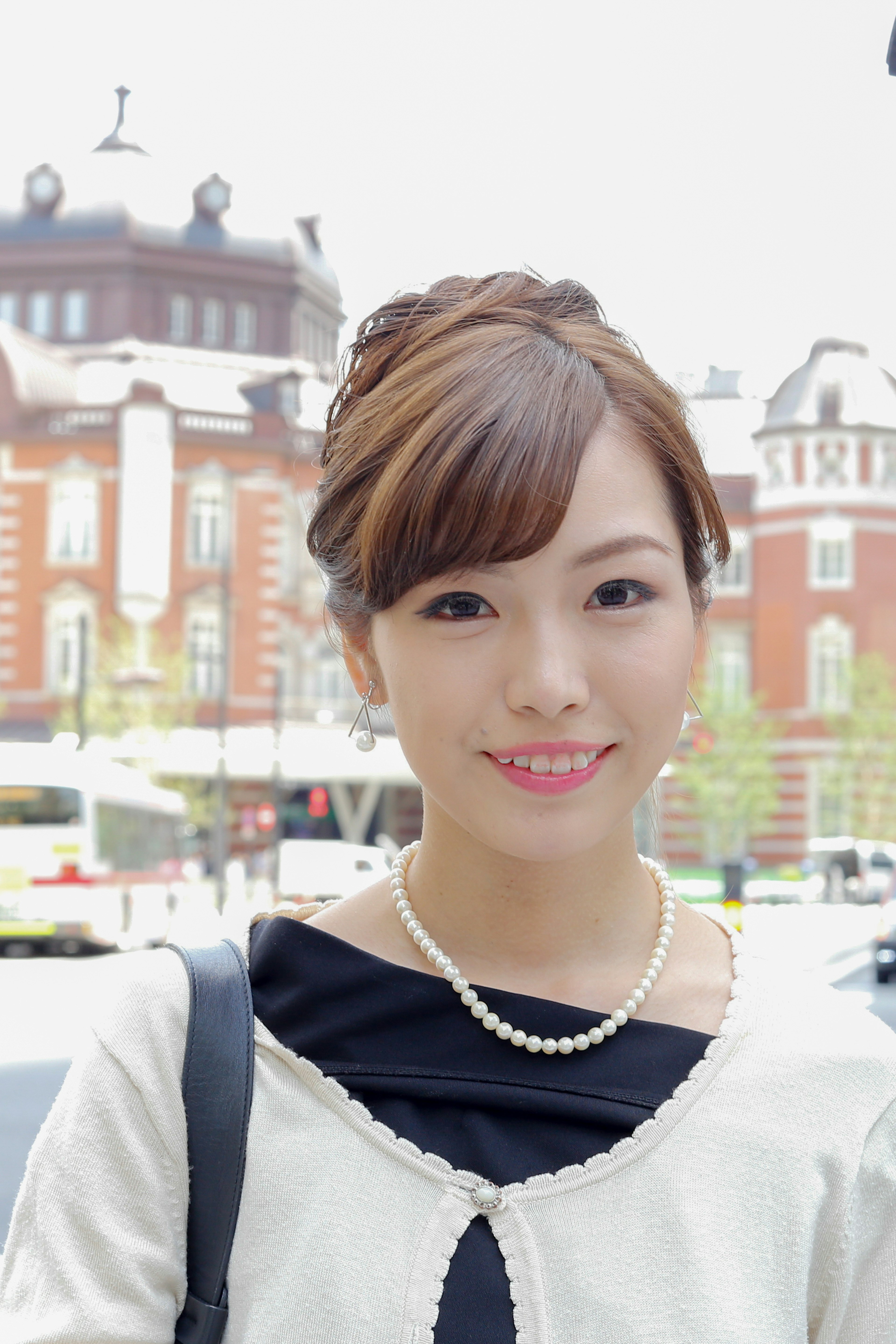 A beautiful woman smiling in front of Tokyo Station