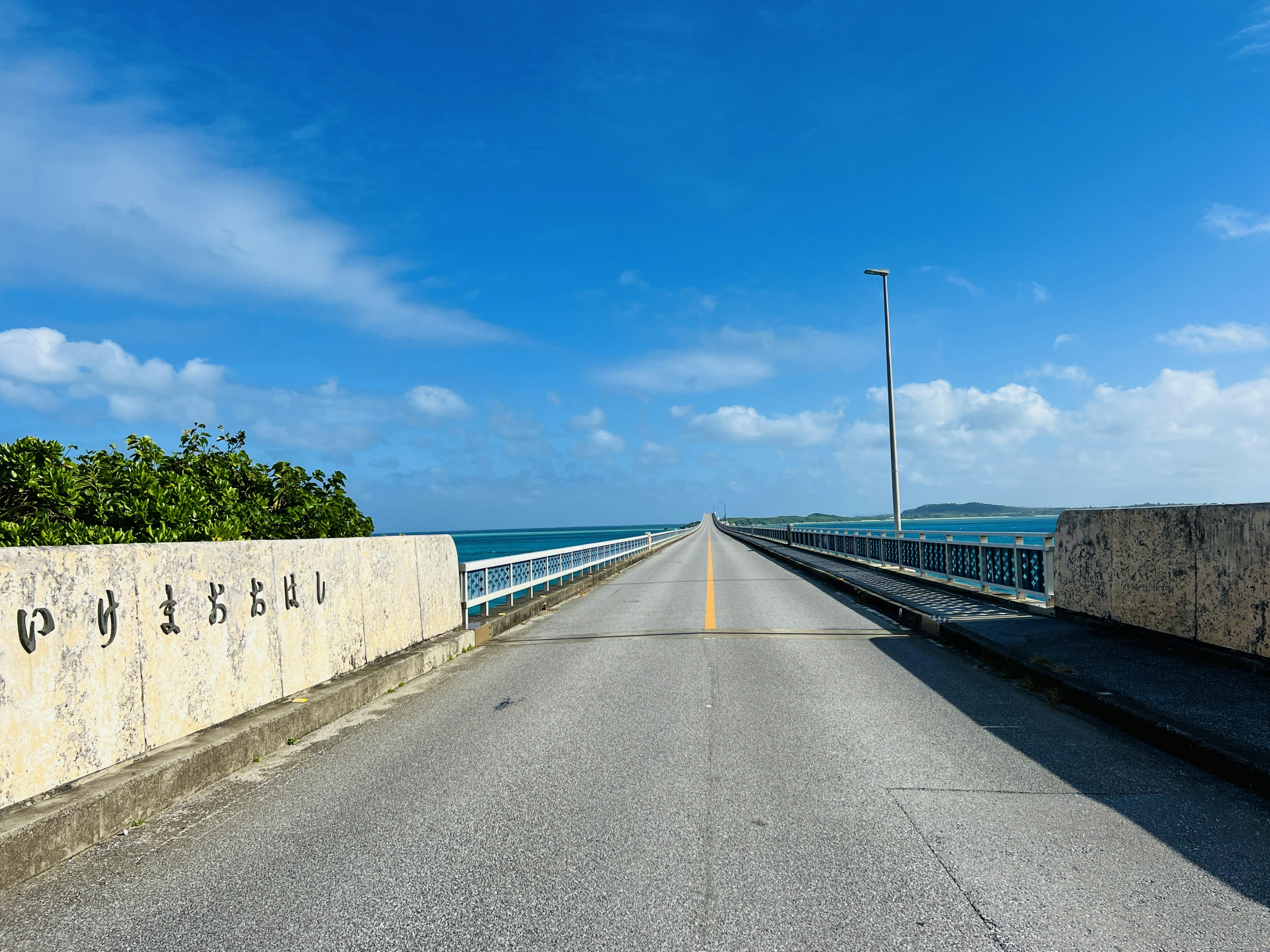 Langer Brücke umgeben von blauem Himmel und Meer