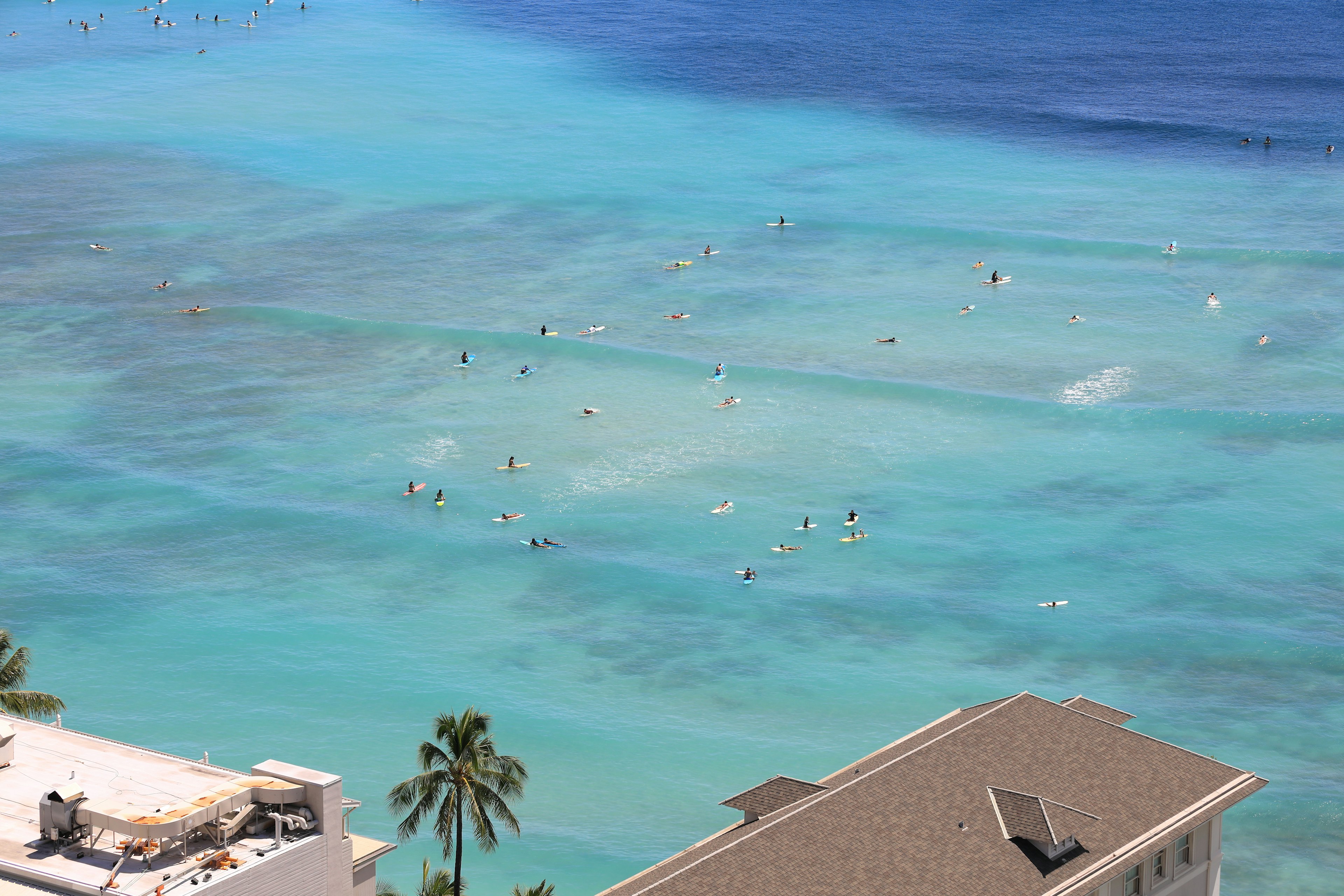 Vue aérienne d'un océan bleu vibrant avec des surfeurs et des paddleboarders