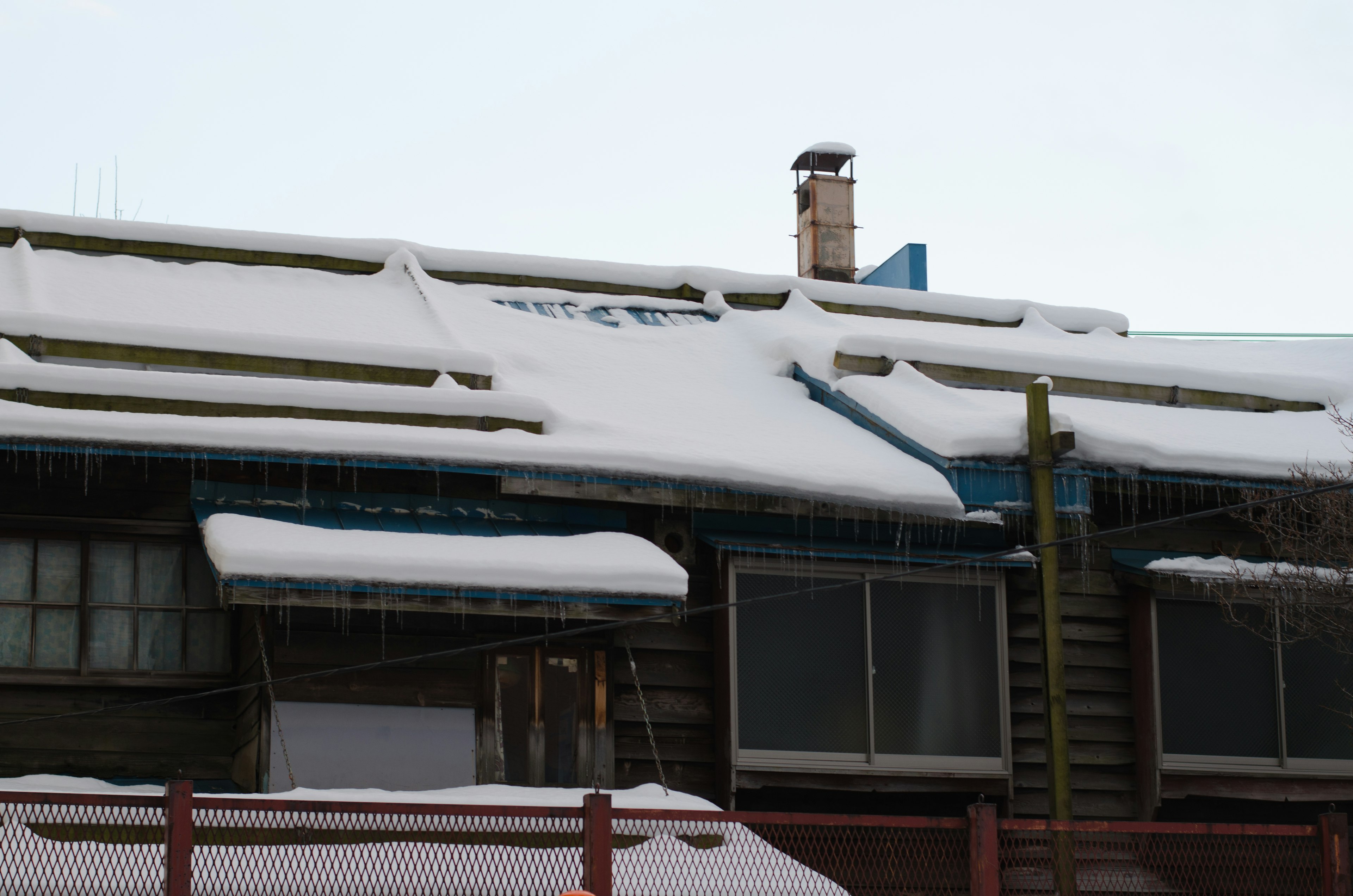 Parte di un vecchio edificio con un tetto coperto di neve