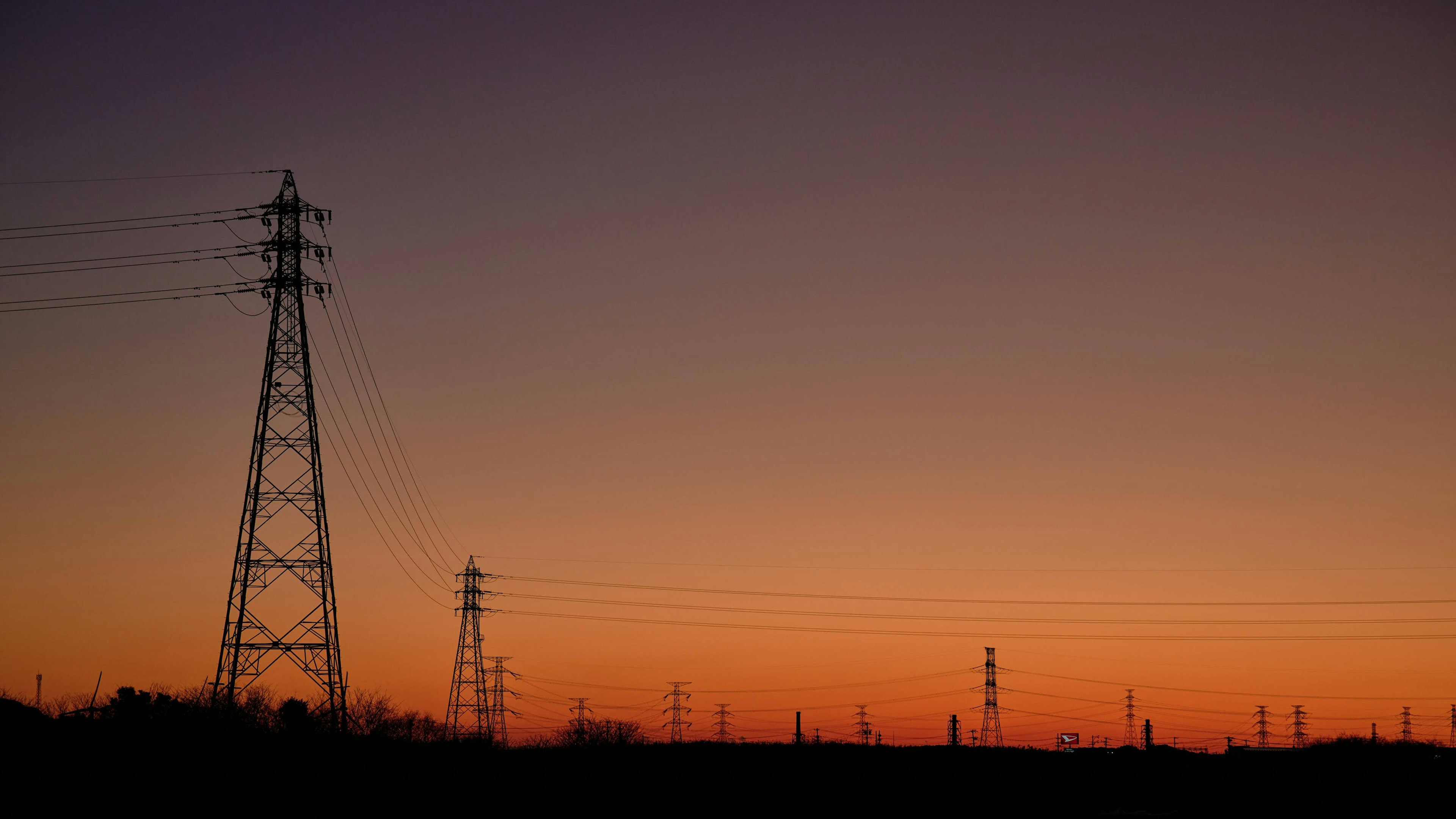 Silhouette of power lines against a sunset sky