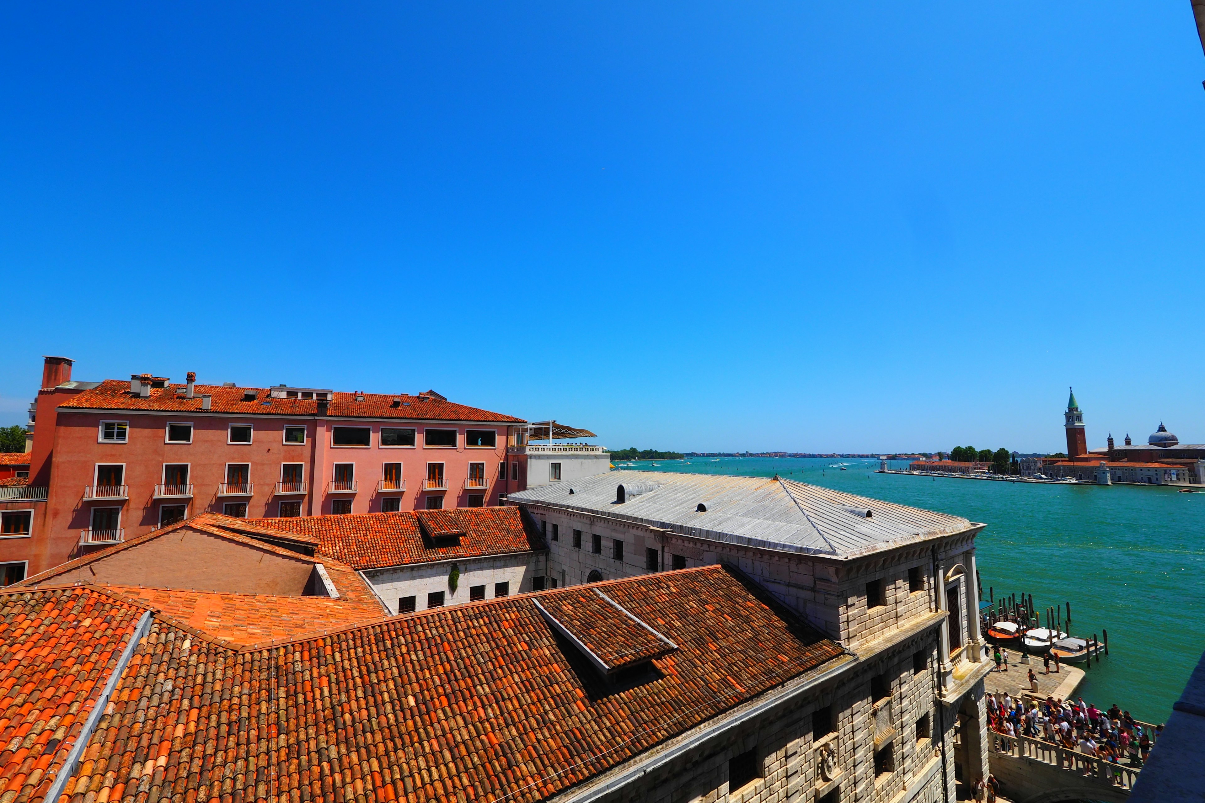 Tetti veneziani che si affacciano su acque blu e cielo sereno