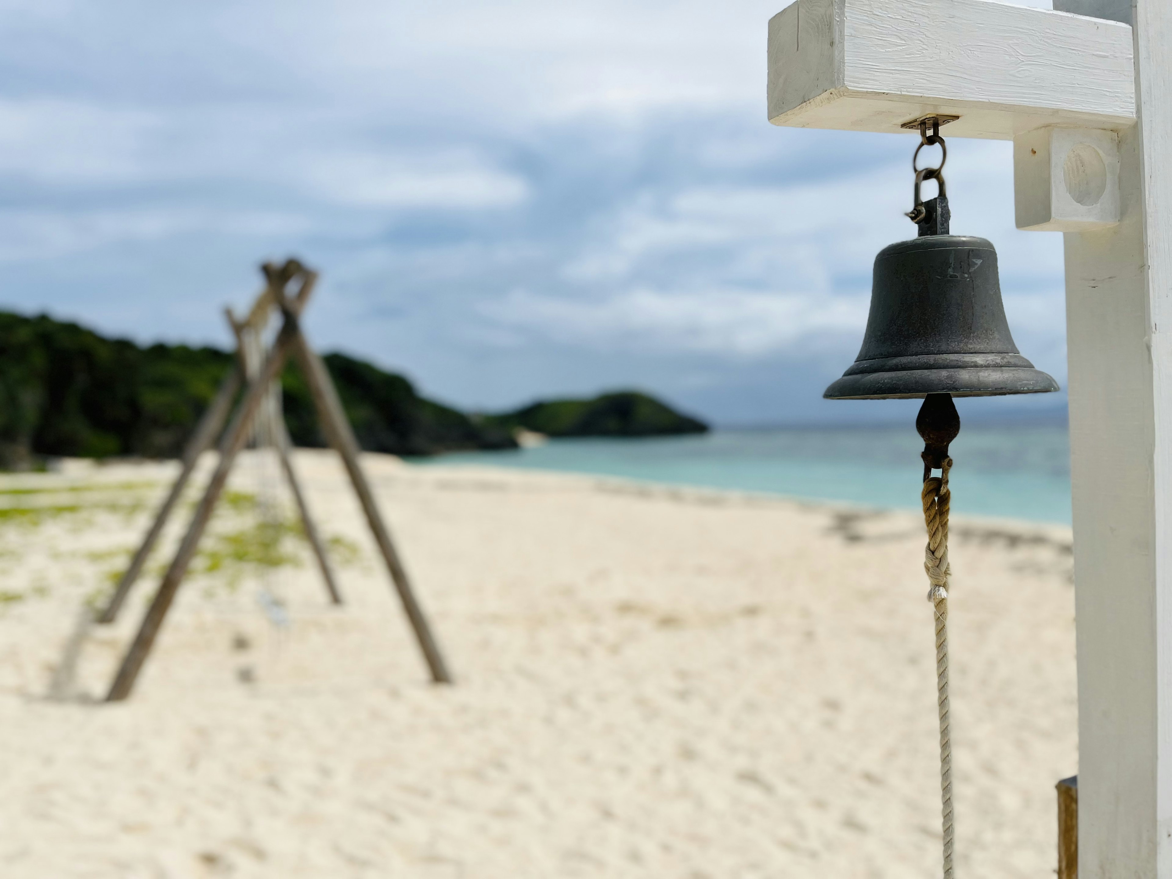 Strandszene mit einer Glocke und einer Holzstruktur