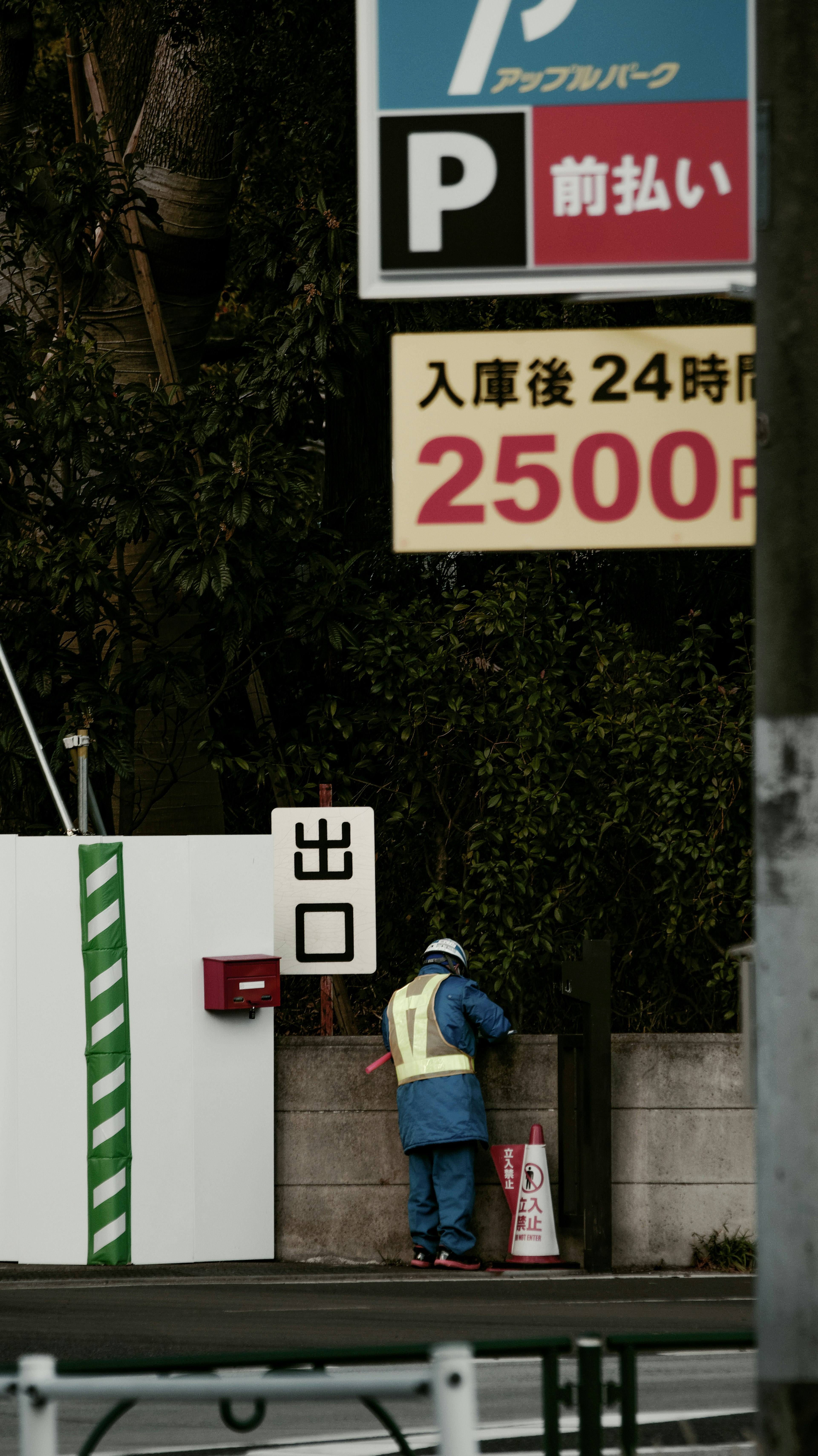 A worker standing at the exit of a parking lot