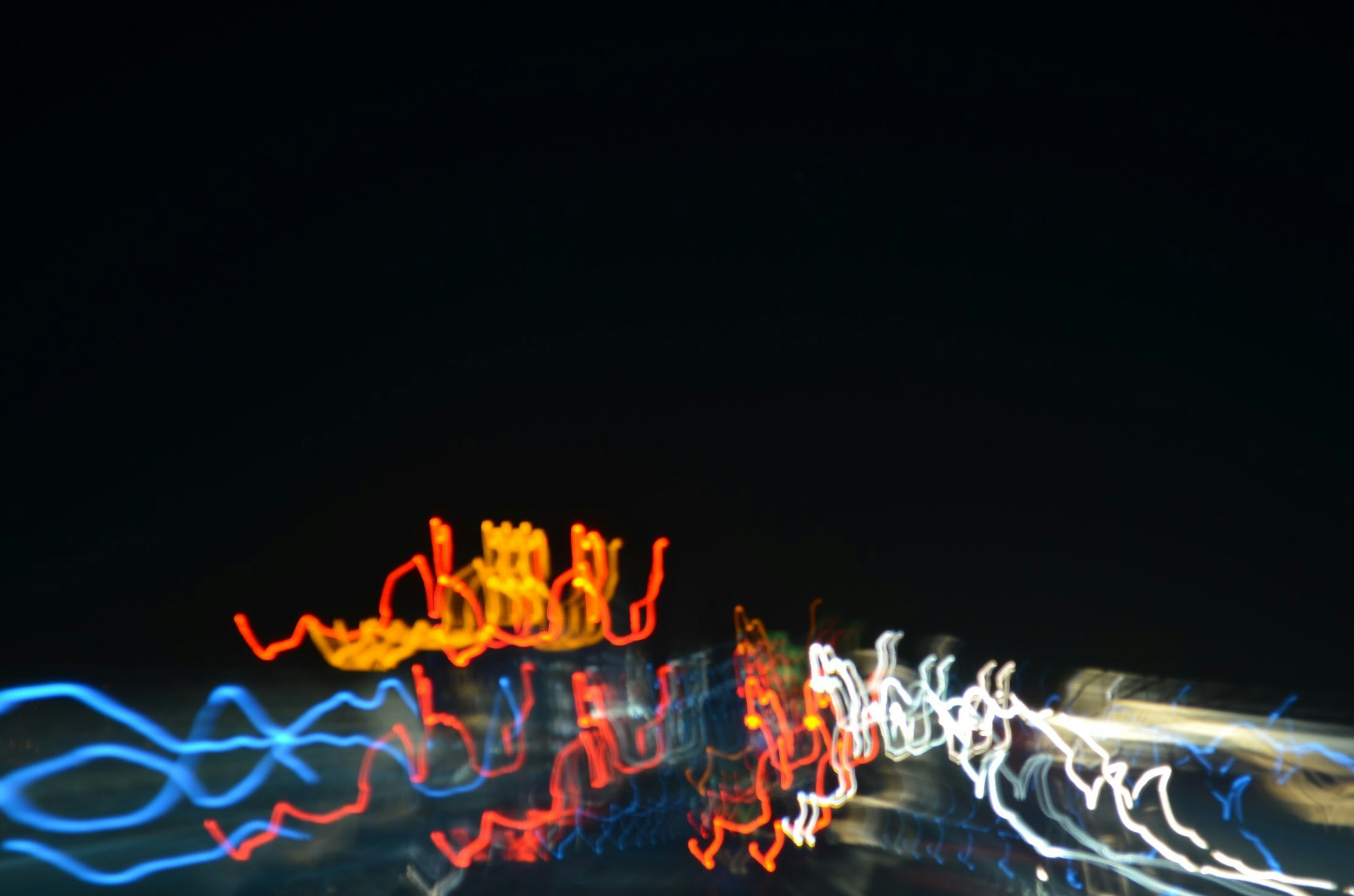 Photo abstraite de lumières de ville coulant la nuit avec des flux de lumière bleue rouge et blanche