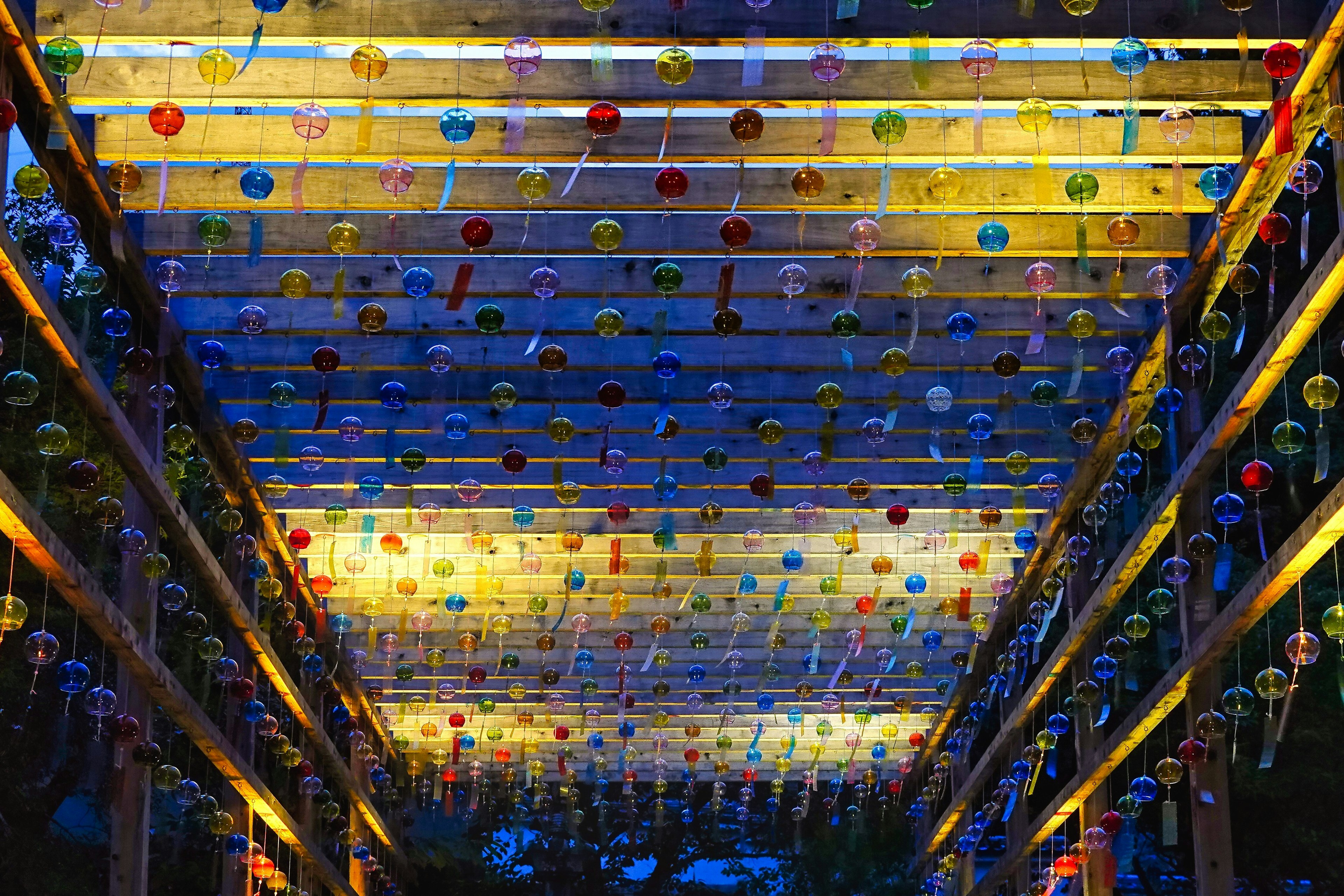 Colorful wind chimes hanging from a beautifully illuminated ceiling