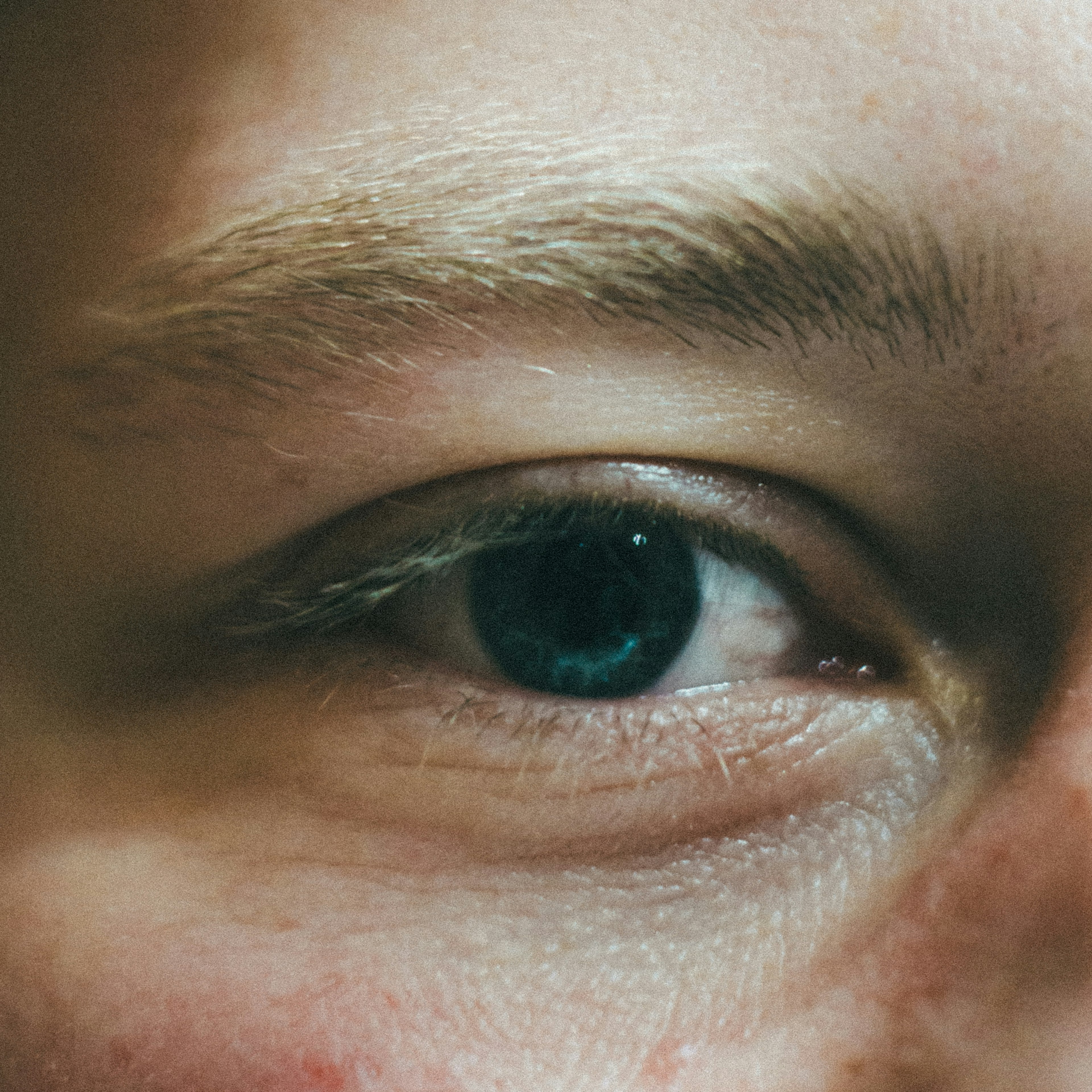 Close-up of an eye featuring a blue iris and light eyelashes