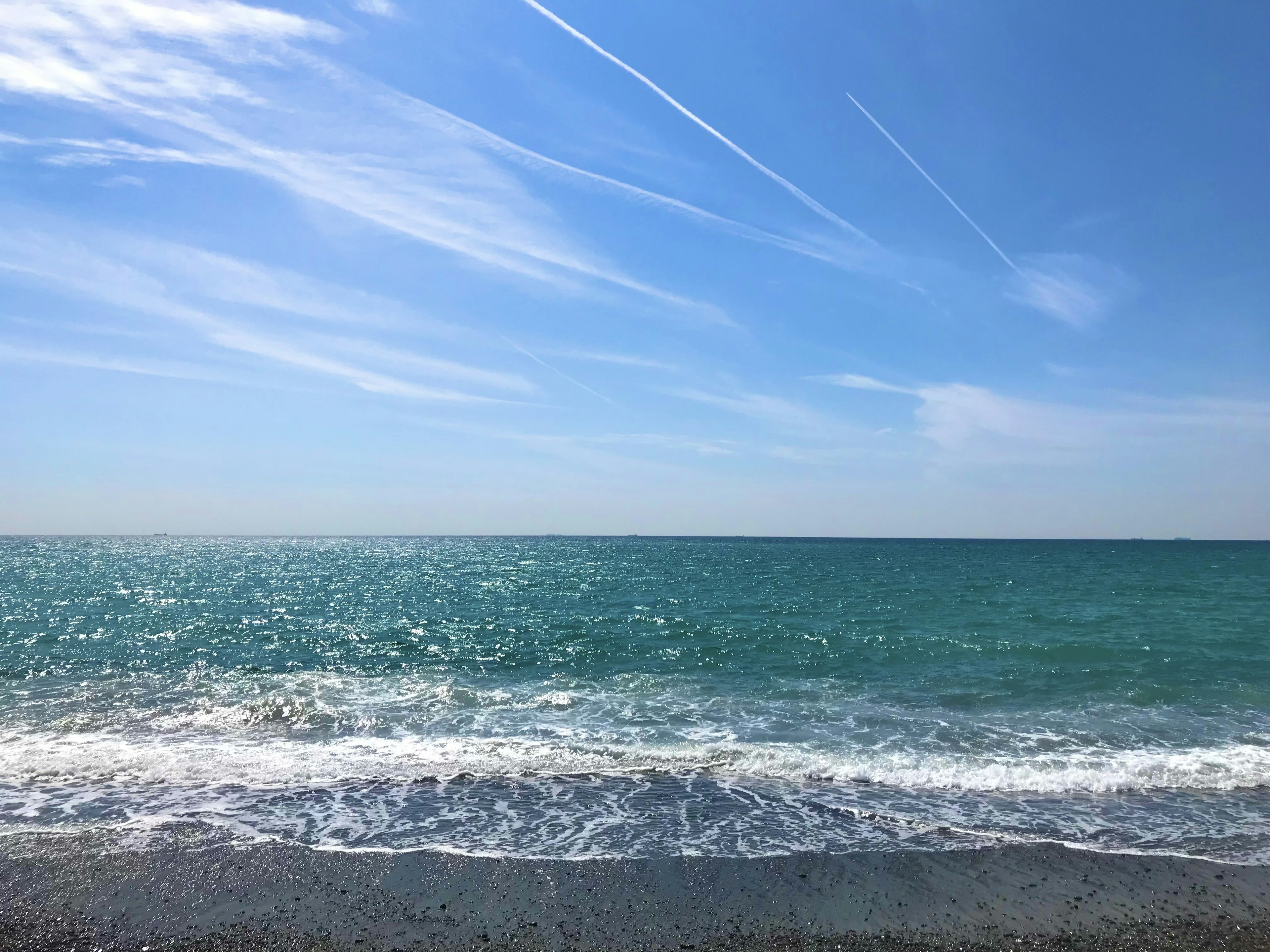 Pemandangan pantai dengan laut dan langit biru yang luas