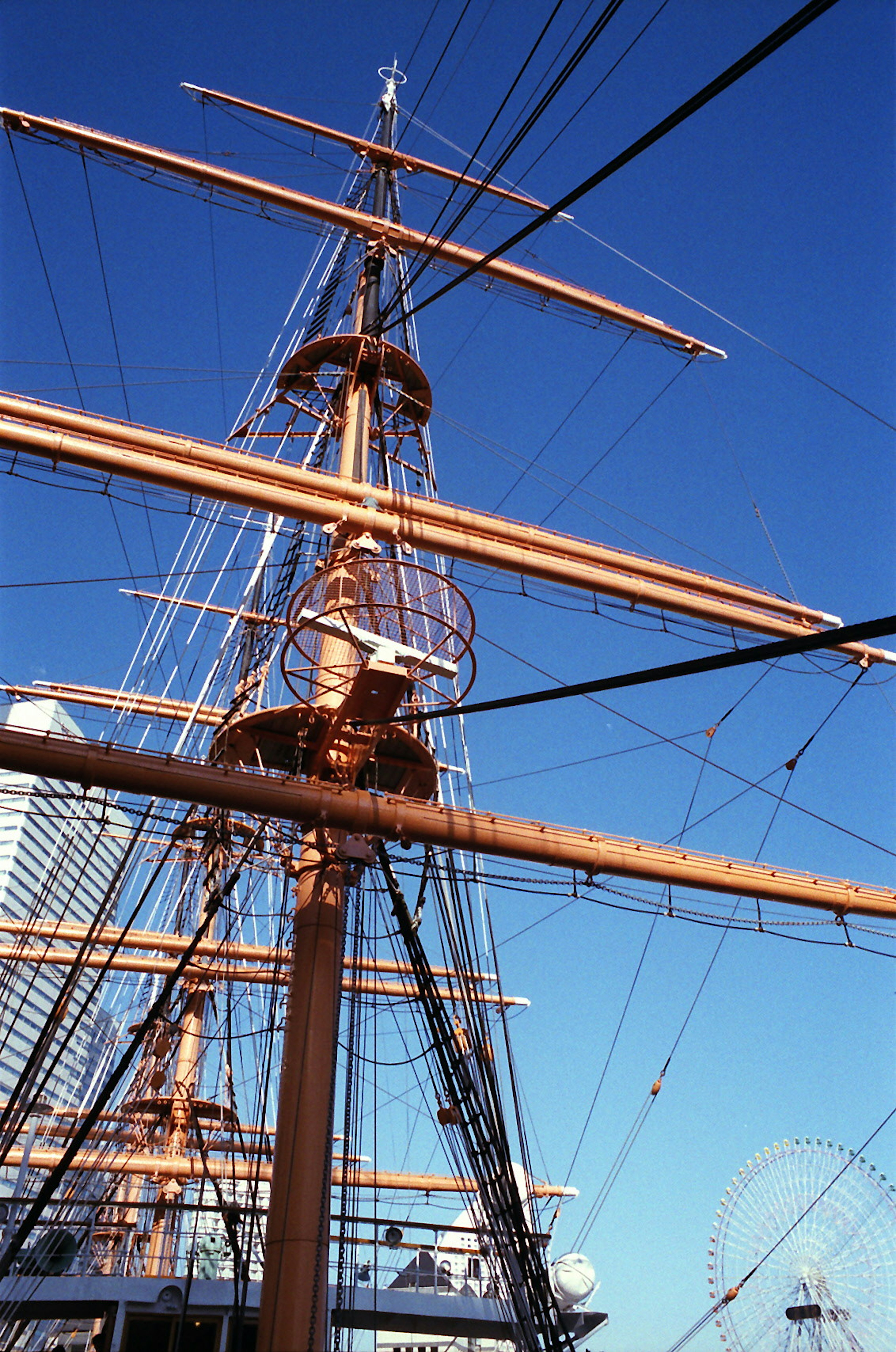 Mast and rigging of a tall ship against a clear blue sky