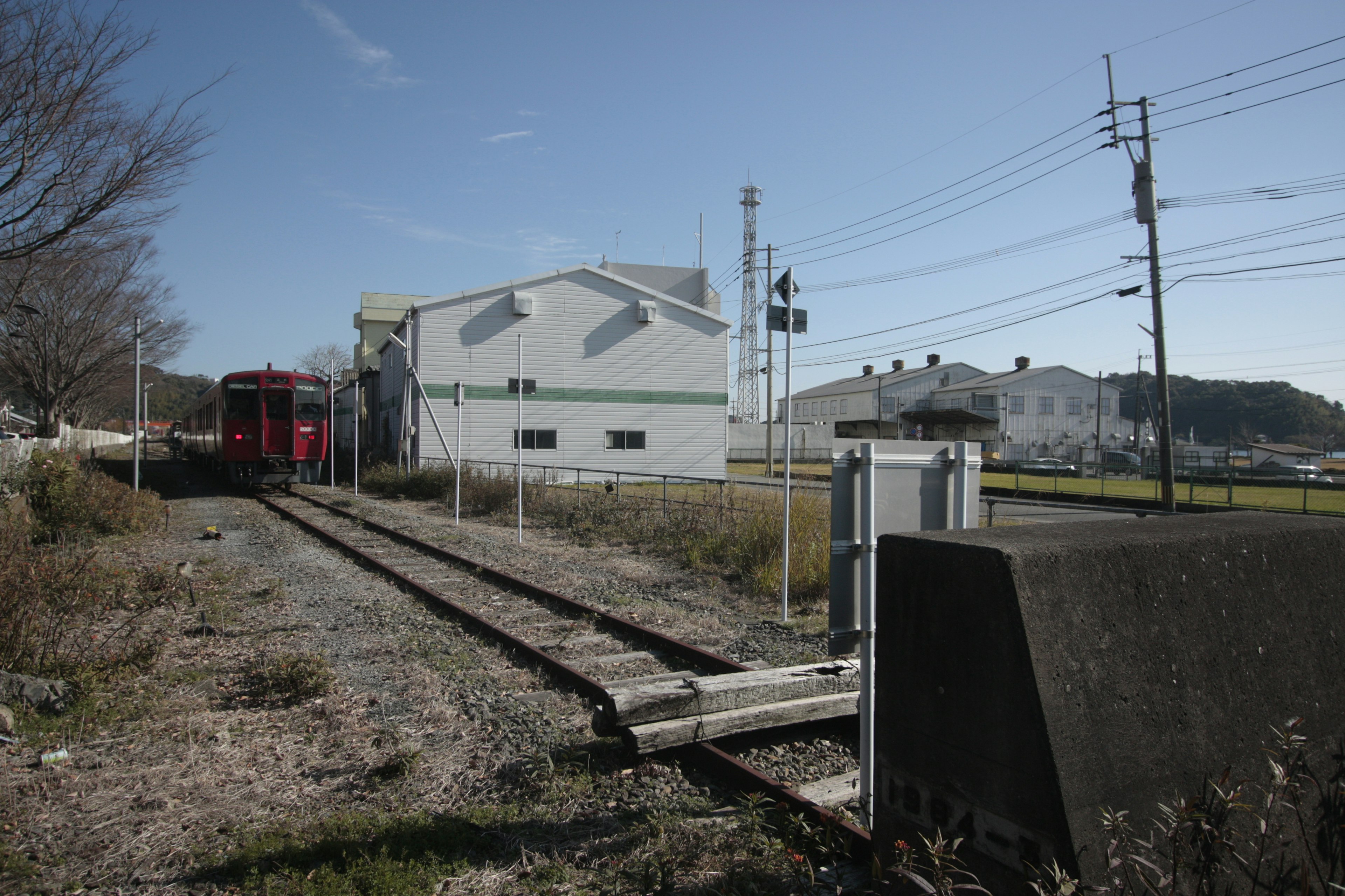 Un treno rosso fermo sui binari vicino a un edificio