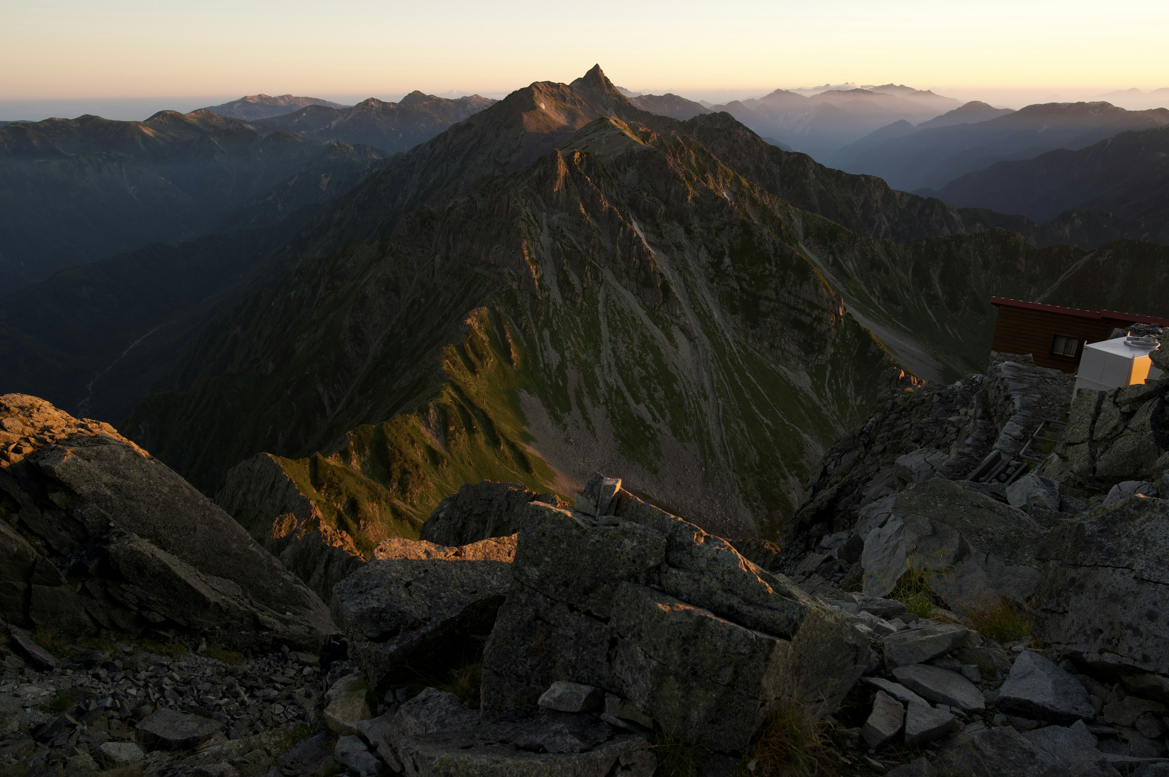 Paysage montagneux au coucher du soleil avec un premier plan rocheux