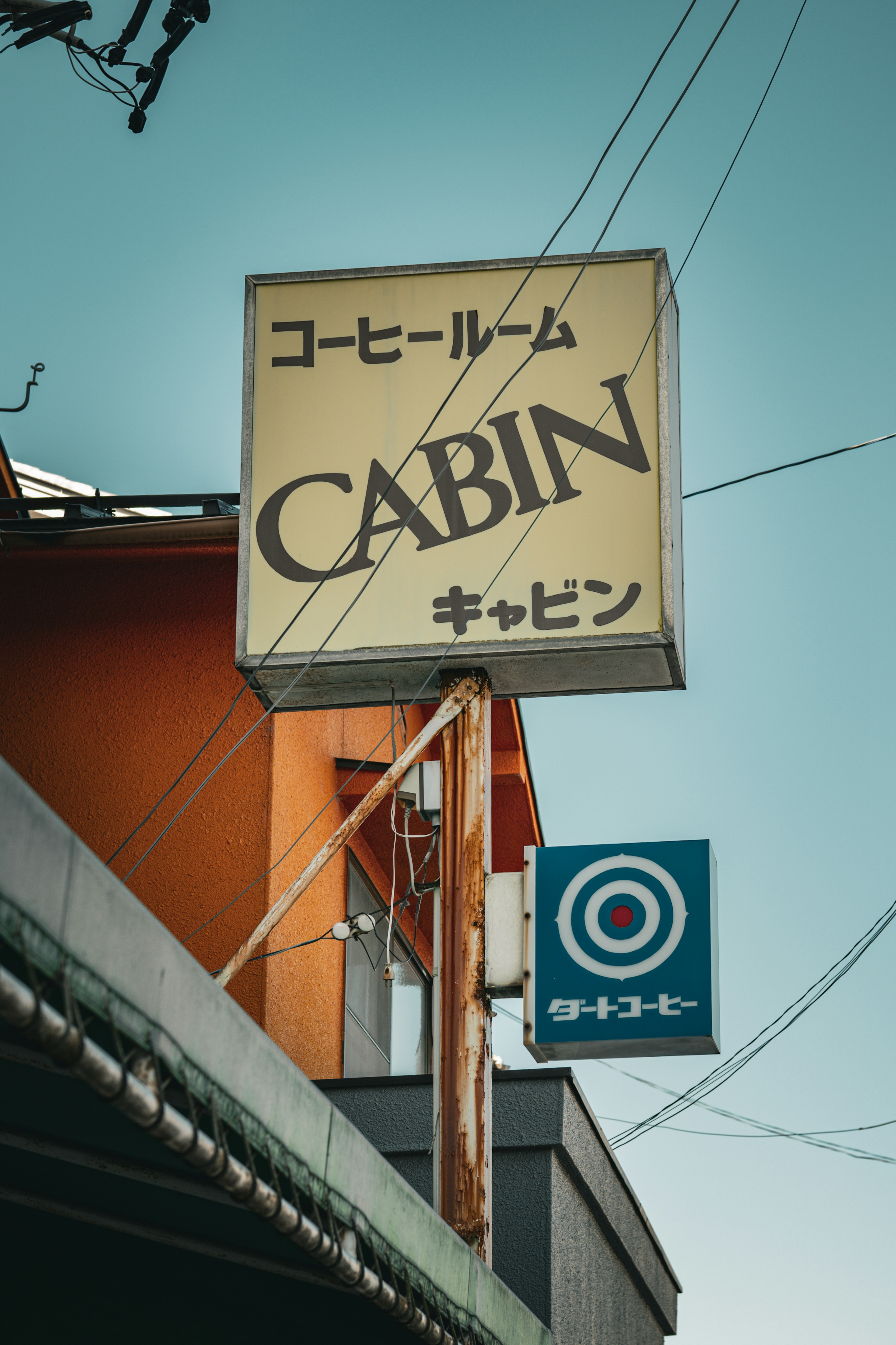 Pemandangan jalan dengan papan nama CABIN dalam bahasa Jepang dan Inggris