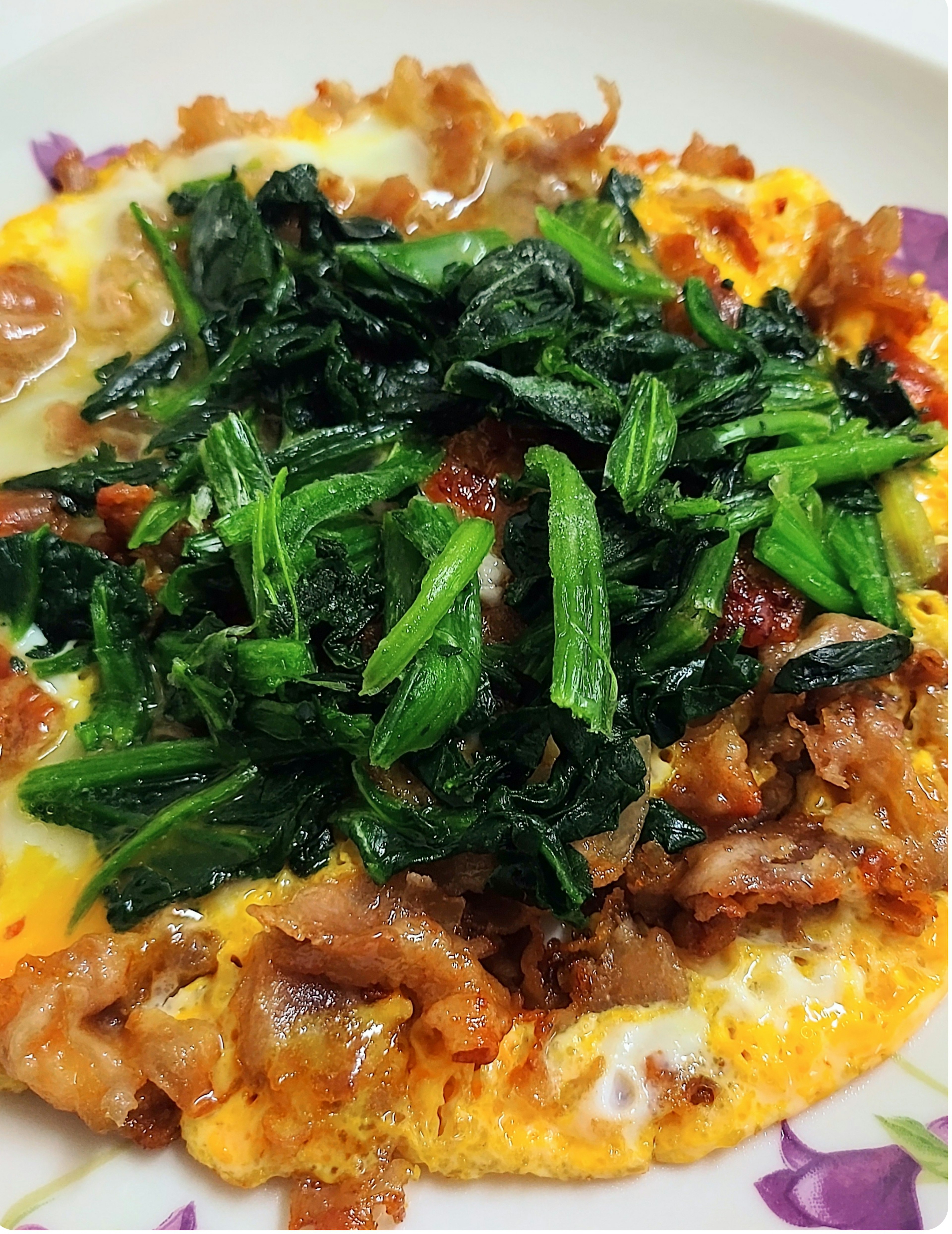 Tortilla cubierta de verduras y carne servida en un plato floral