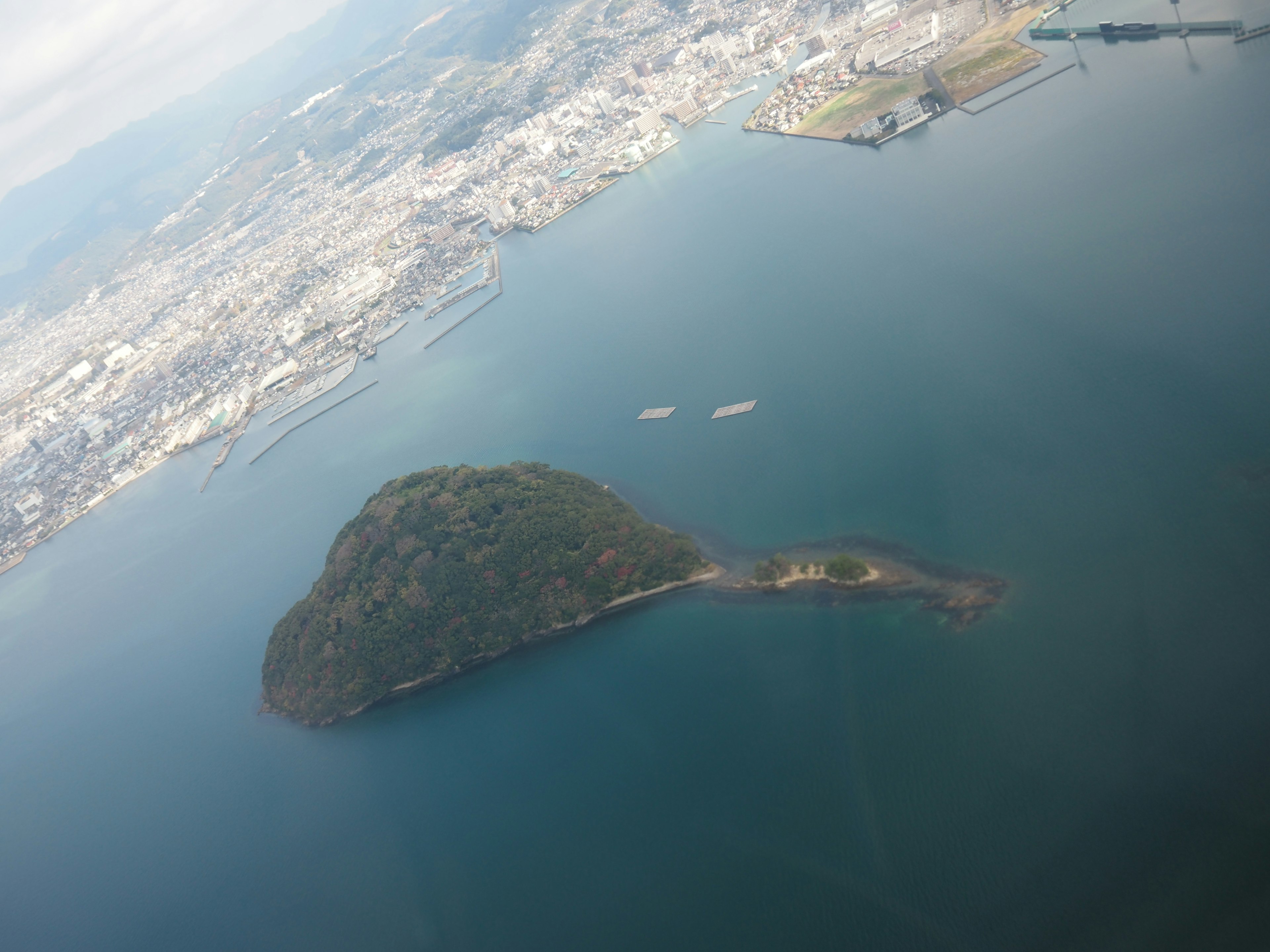 Vista aérea de una pequeña isla rodeada de agua y paisaje urbano