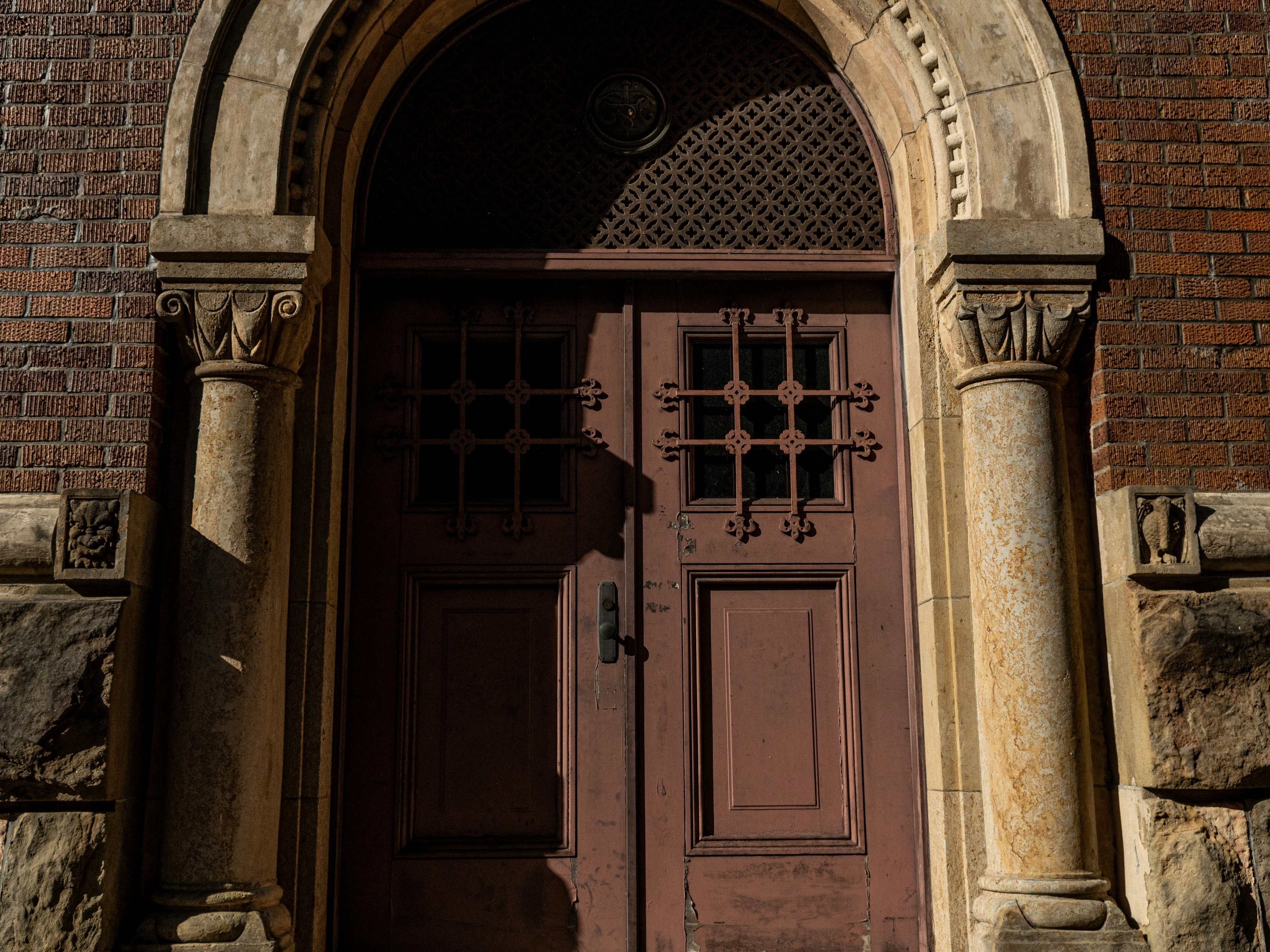 Porte en bois décorative d'un vieux bâtiment avec fenêtre en arc et colonnes ornées