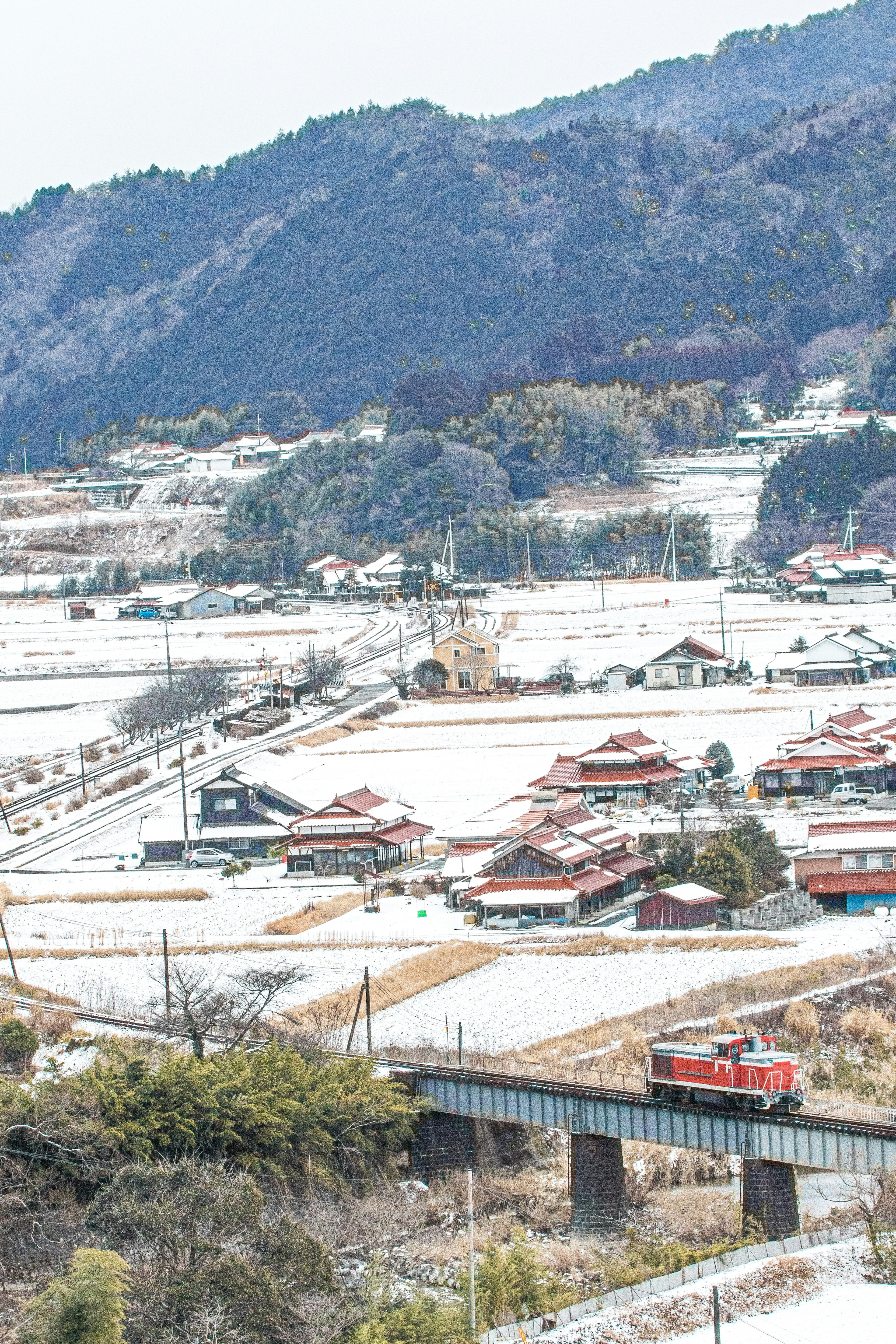 Pueblo cubierto de nieve con un tren que pasa por el paisaje