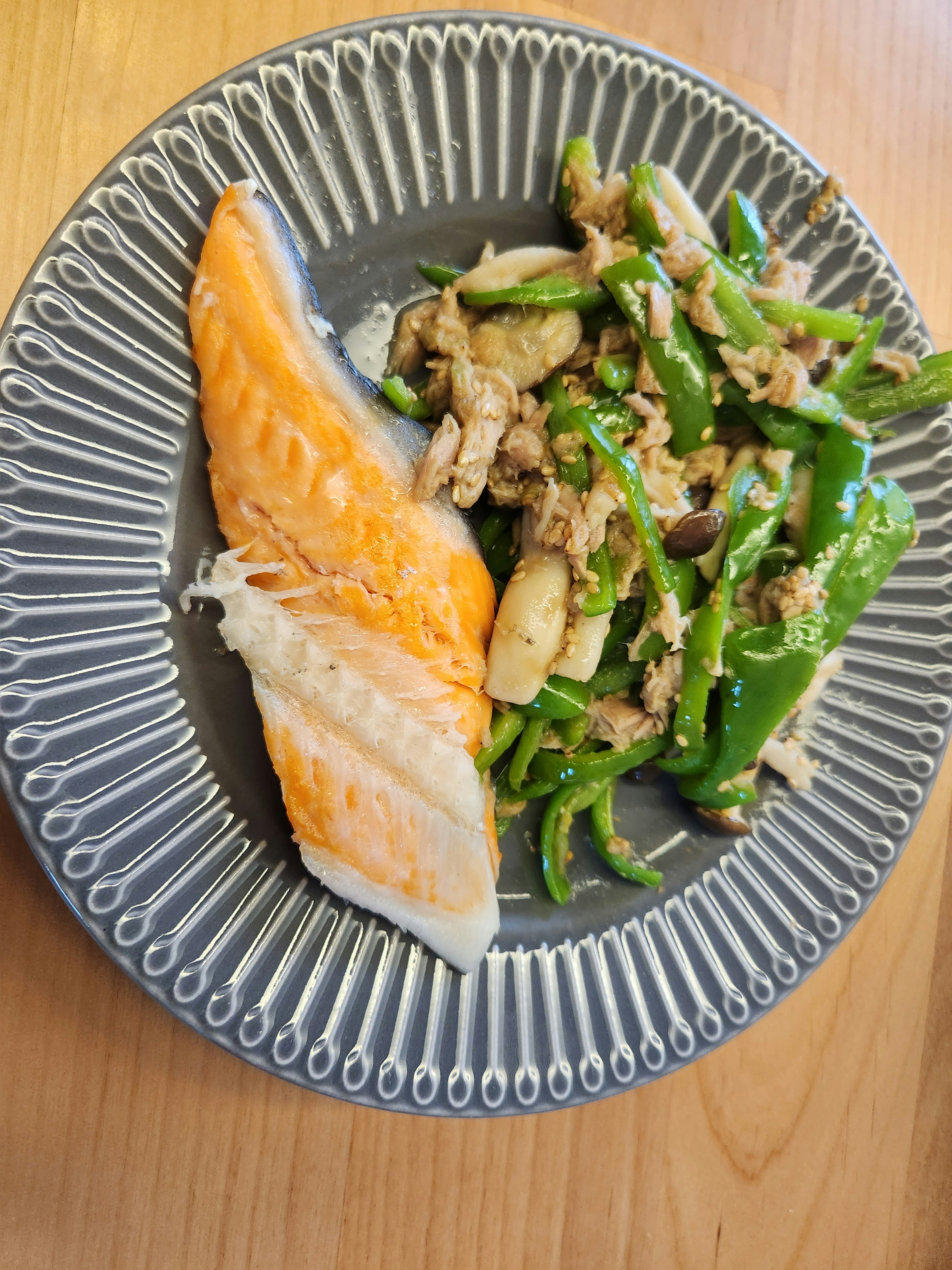 鮭と緑の野菜の料理が盛り付けられた皿