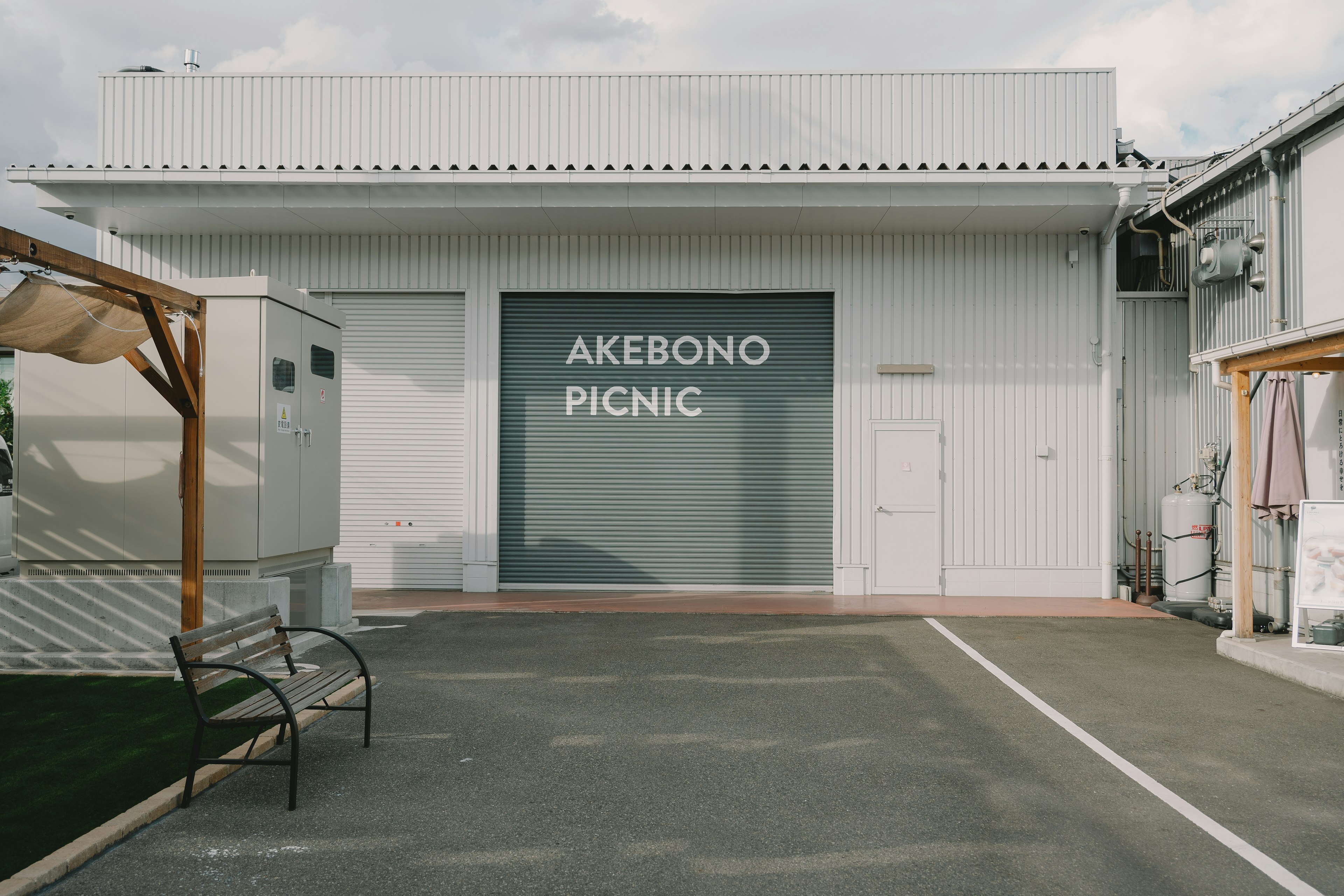 ภายนอกอาคารสีขาวที่มีตัวอักษรใหญ่เขียนว่า AKEBONO PICNIC