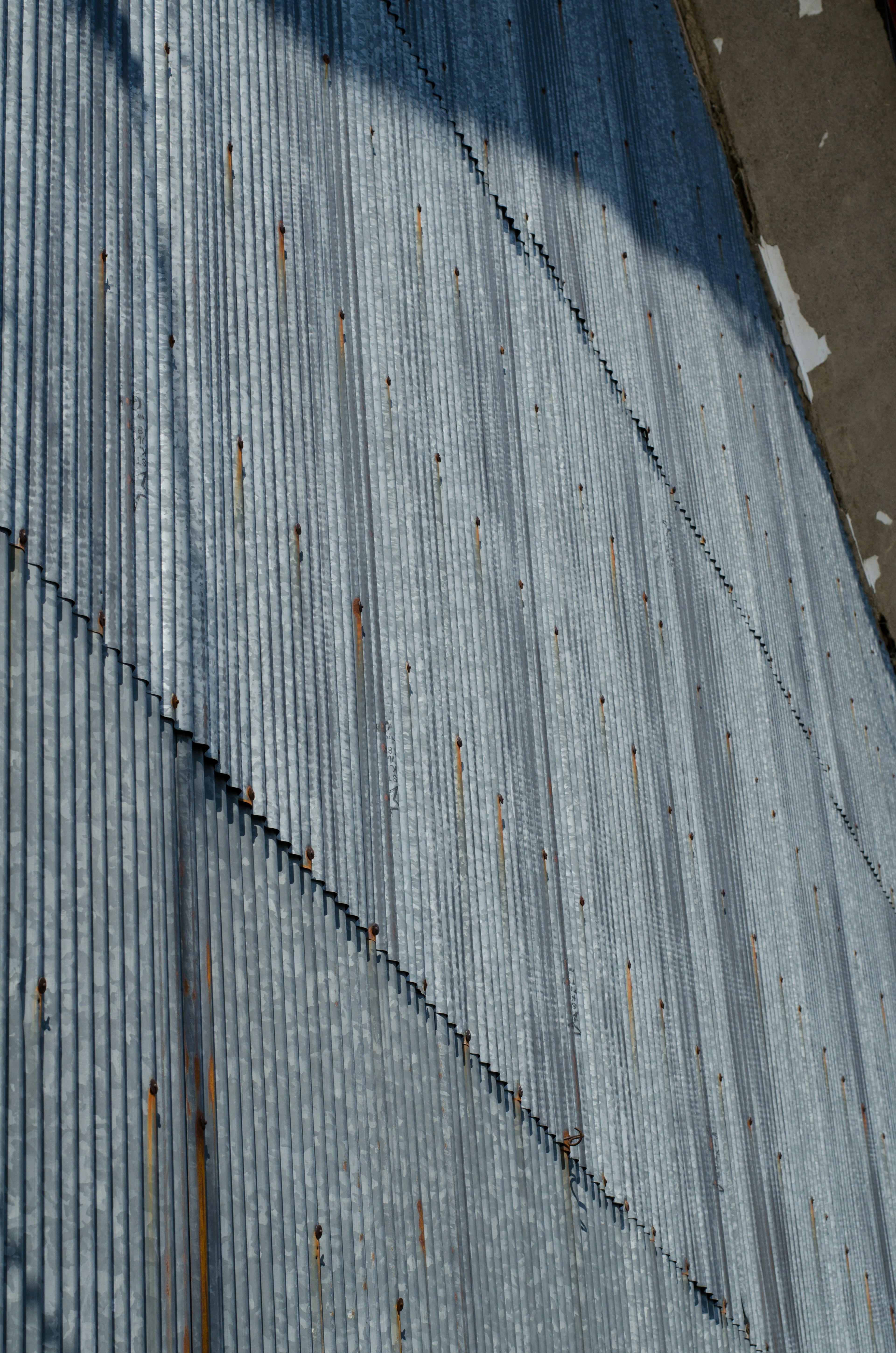 Close-up of a corrugated metal roof showing blue hues and rust patterns