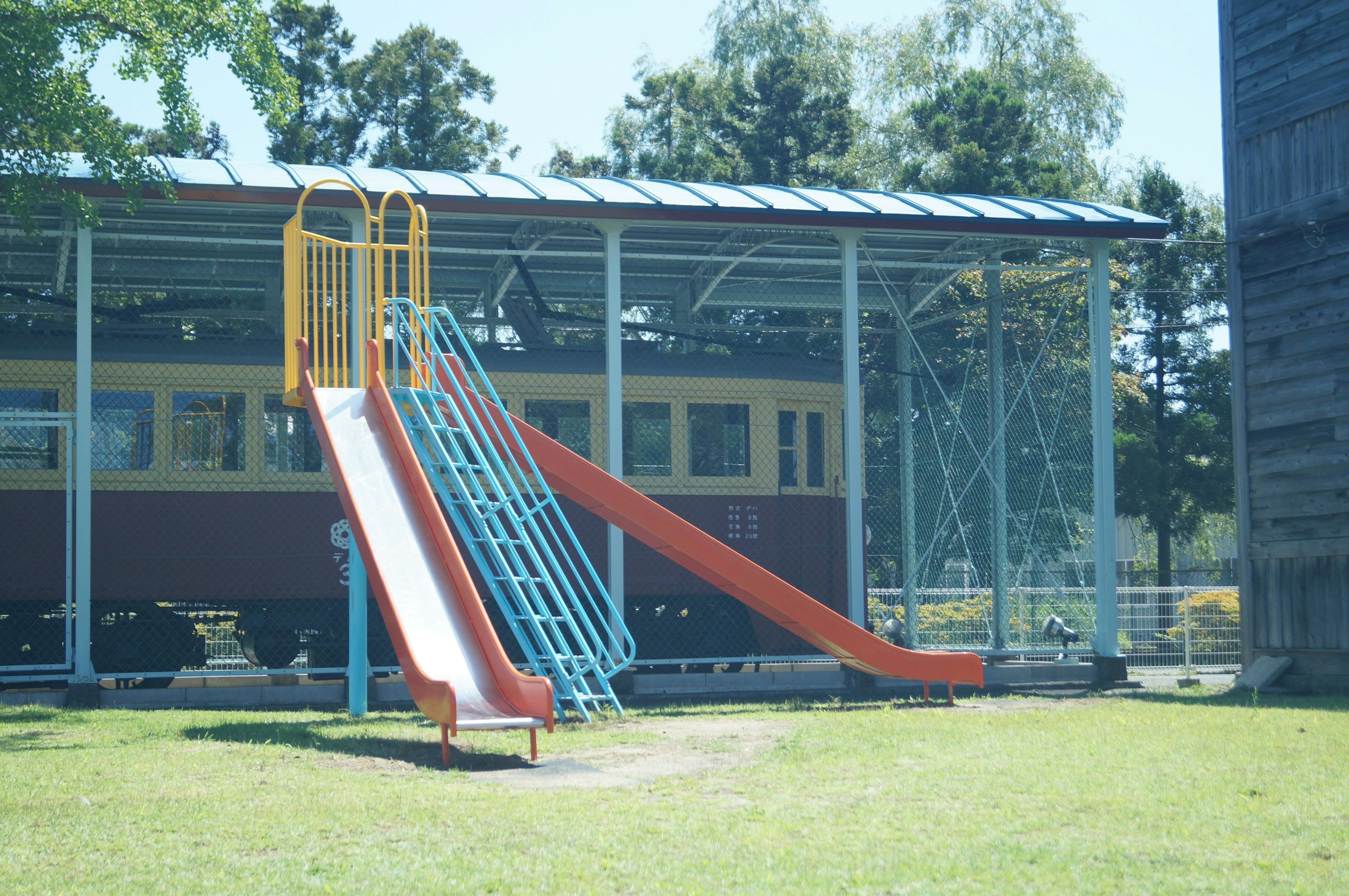 Playground featuring colorful slides and a train structure